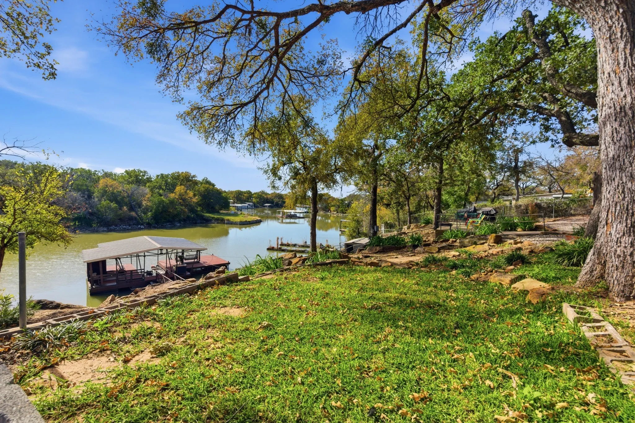 Gently sloping waterfront yard leading toward the covered dock.