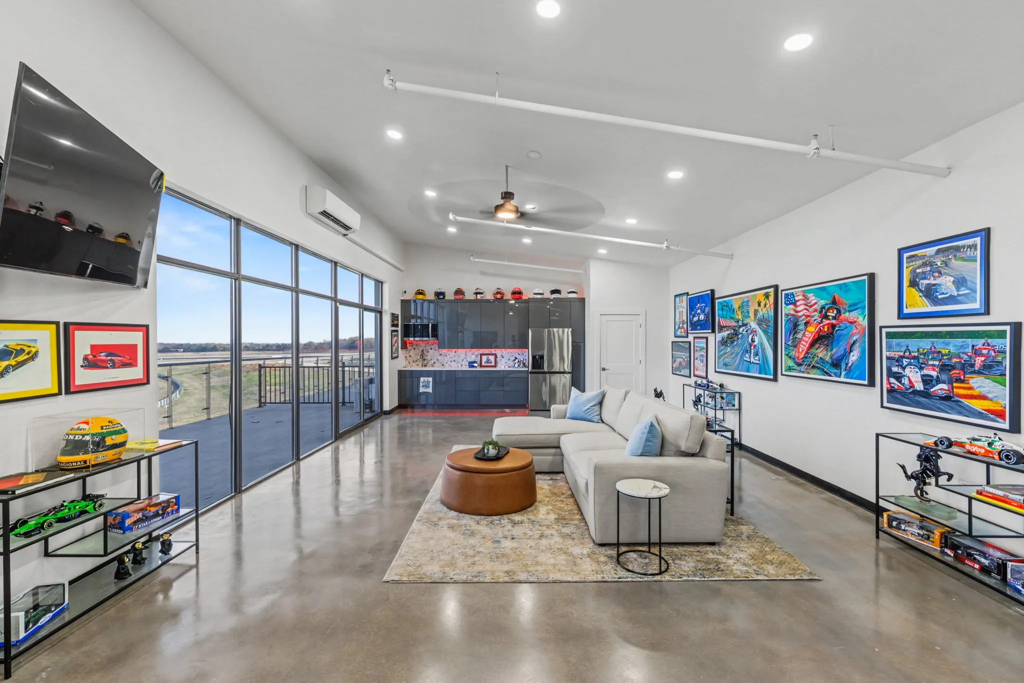 Living area featuring concrete floors, ceiling fan, recessed lighting, and a high ceiling
