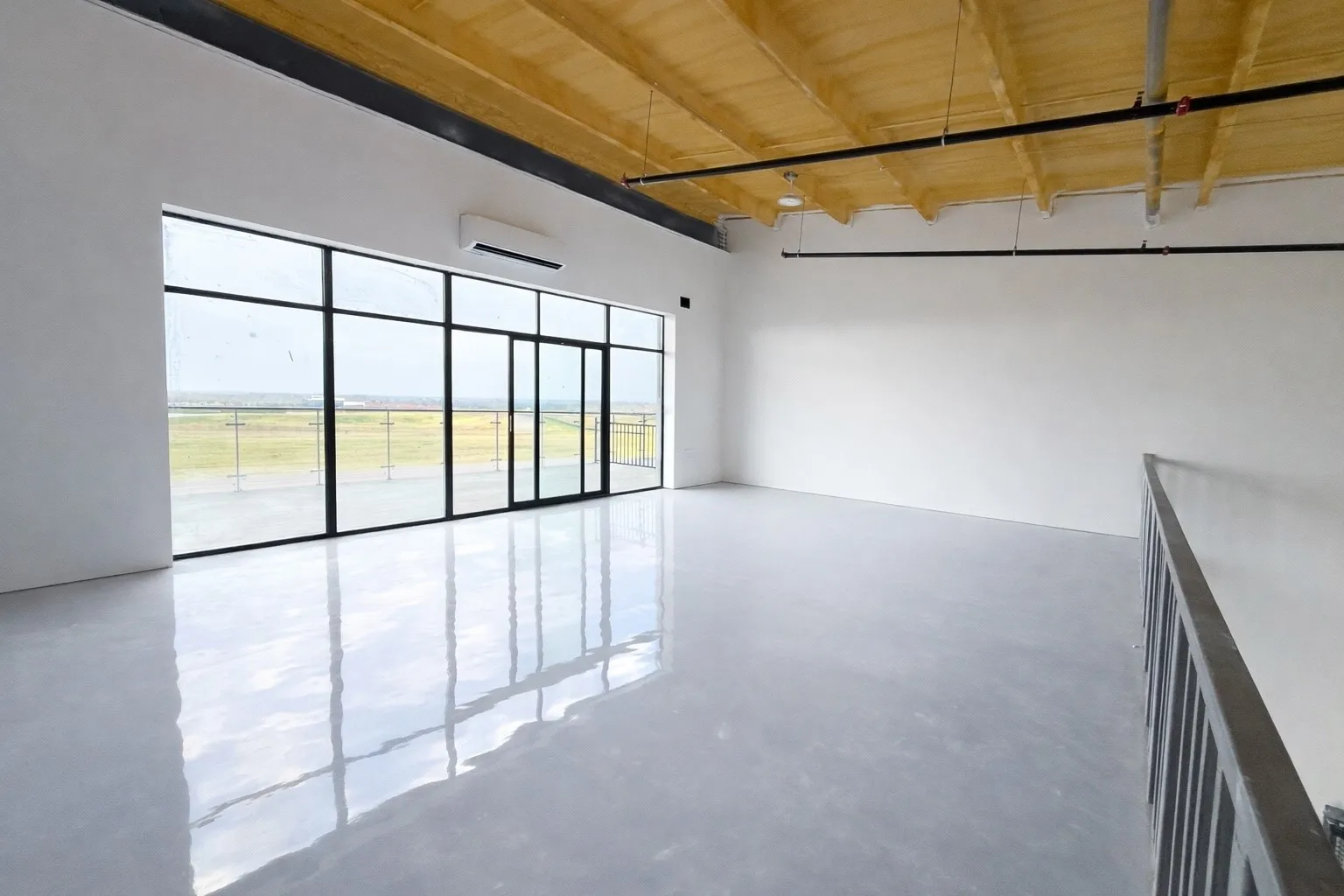 Unfurnished room with concrete flooring, a wooden ceiling with exposed beams, and a mini split for heating / cooling