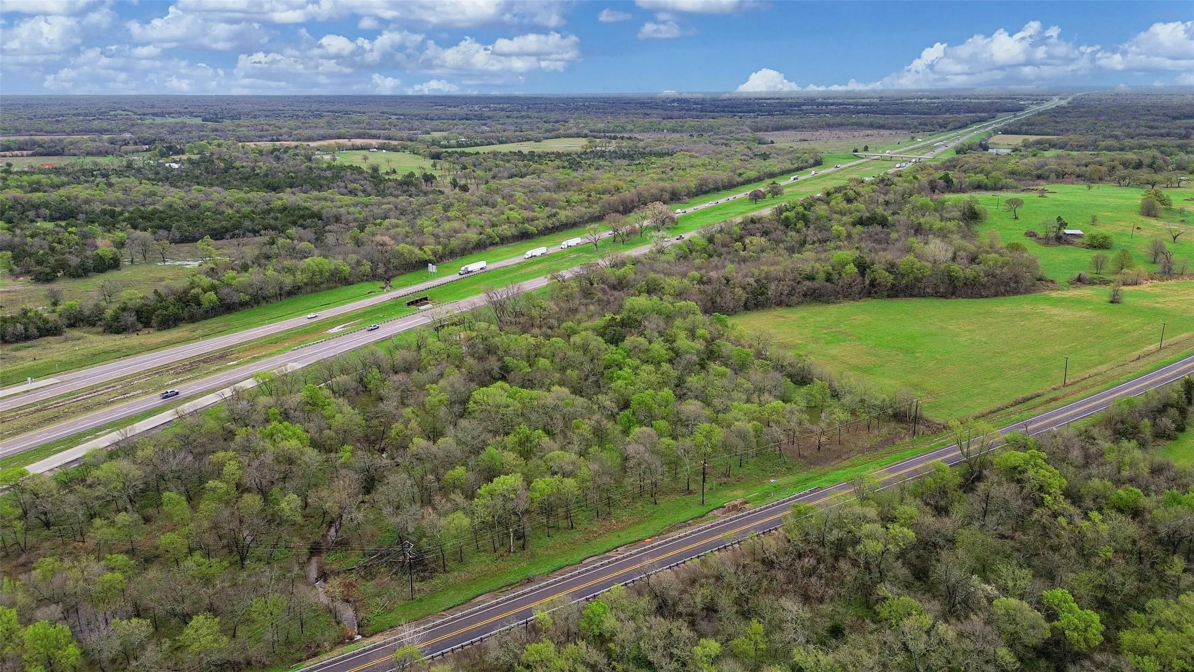 Aerial view of sparsely populated area with a heavily wooded area