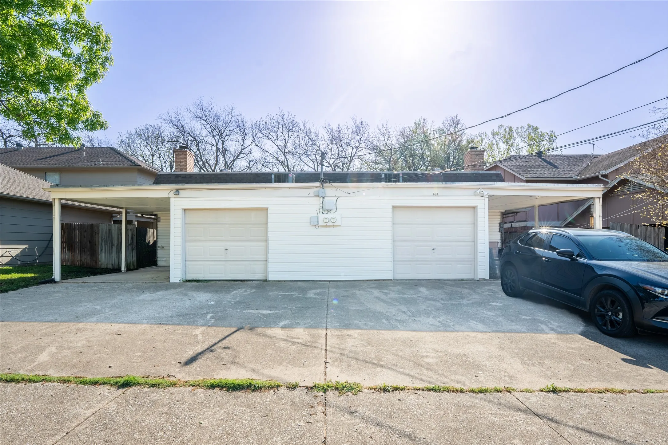 Garage featuring fence and a detached garage