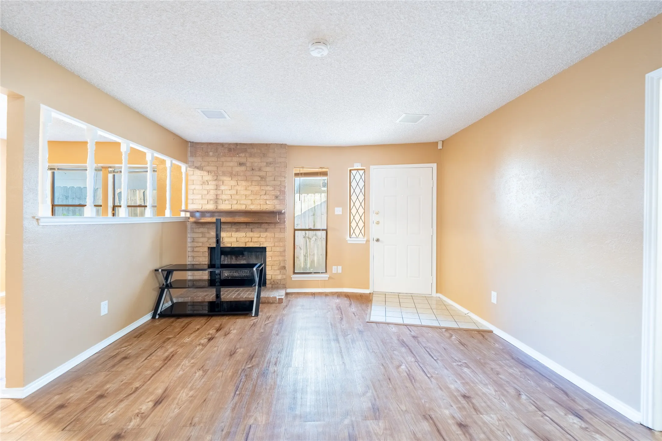 Entrance foyer with baseboards, wood finished floors, and a textured ceiling