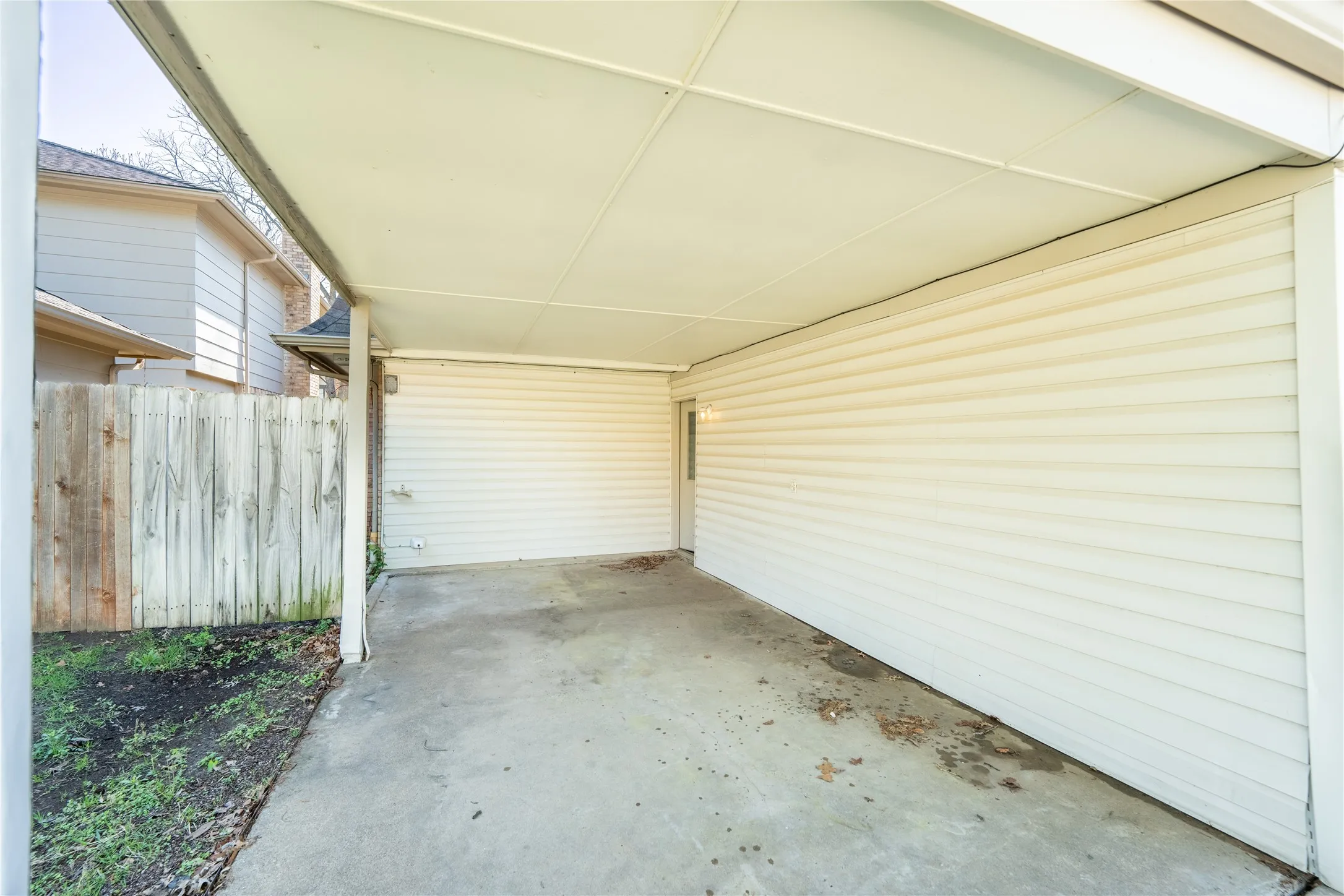 View of patio featuring a carport and fence