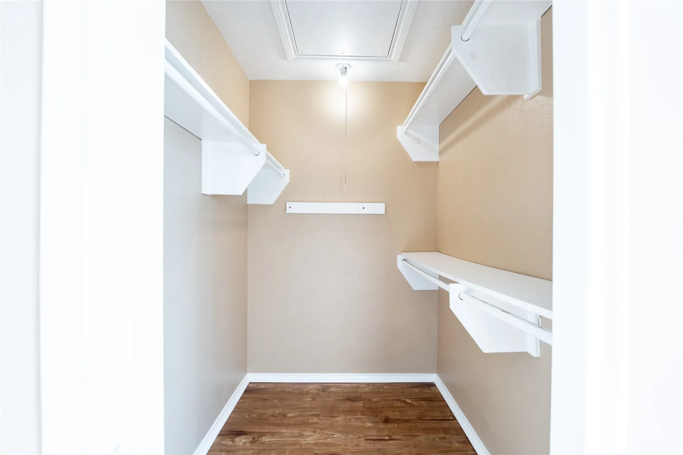 Spacious closet featuring attic access and wood finished floors