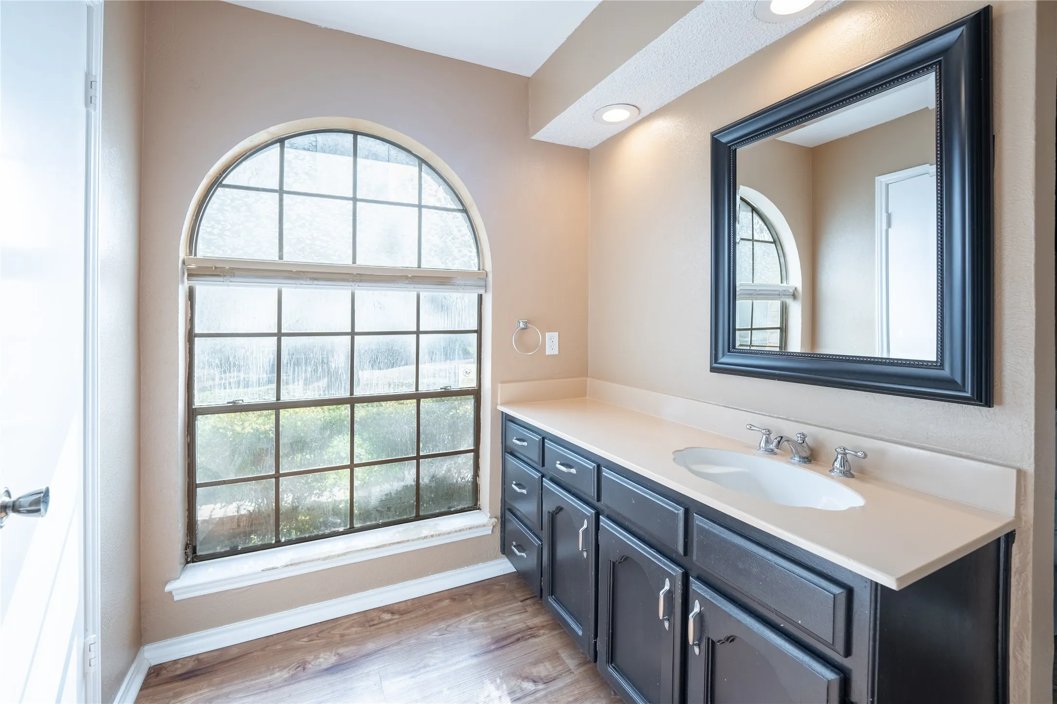 Bathroom with a wealth of natural light, vanity, wood finished floors, and baseboards