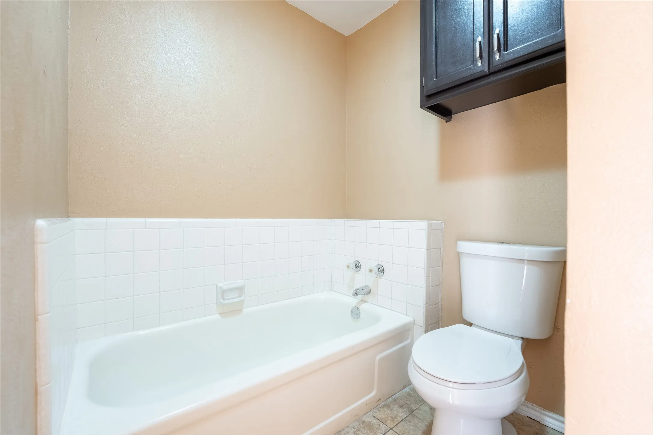 Full bath with tile patterned floors, a bath, and toilet