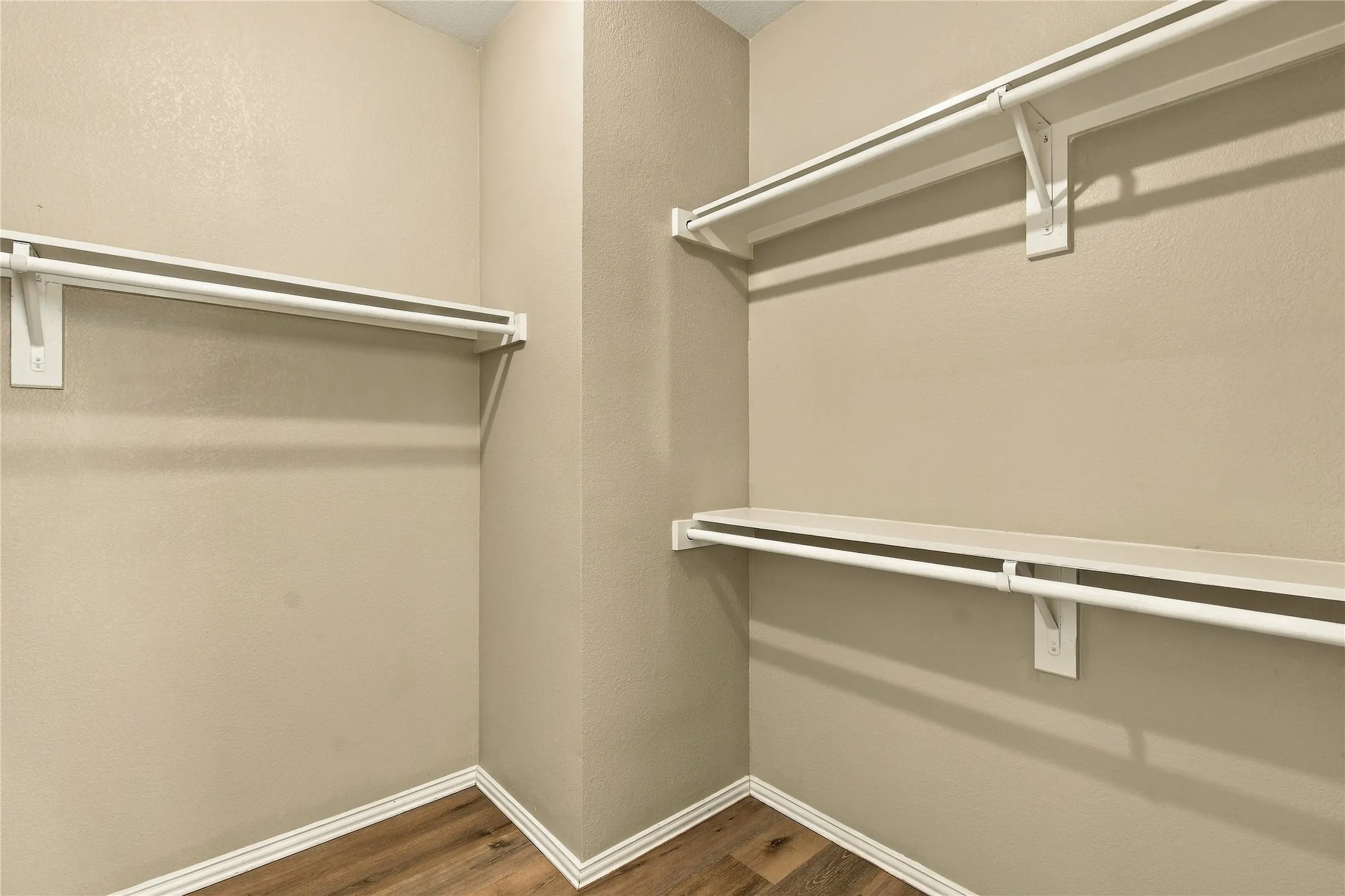Built-in shelving with hanging rods and wood-finish flooring
