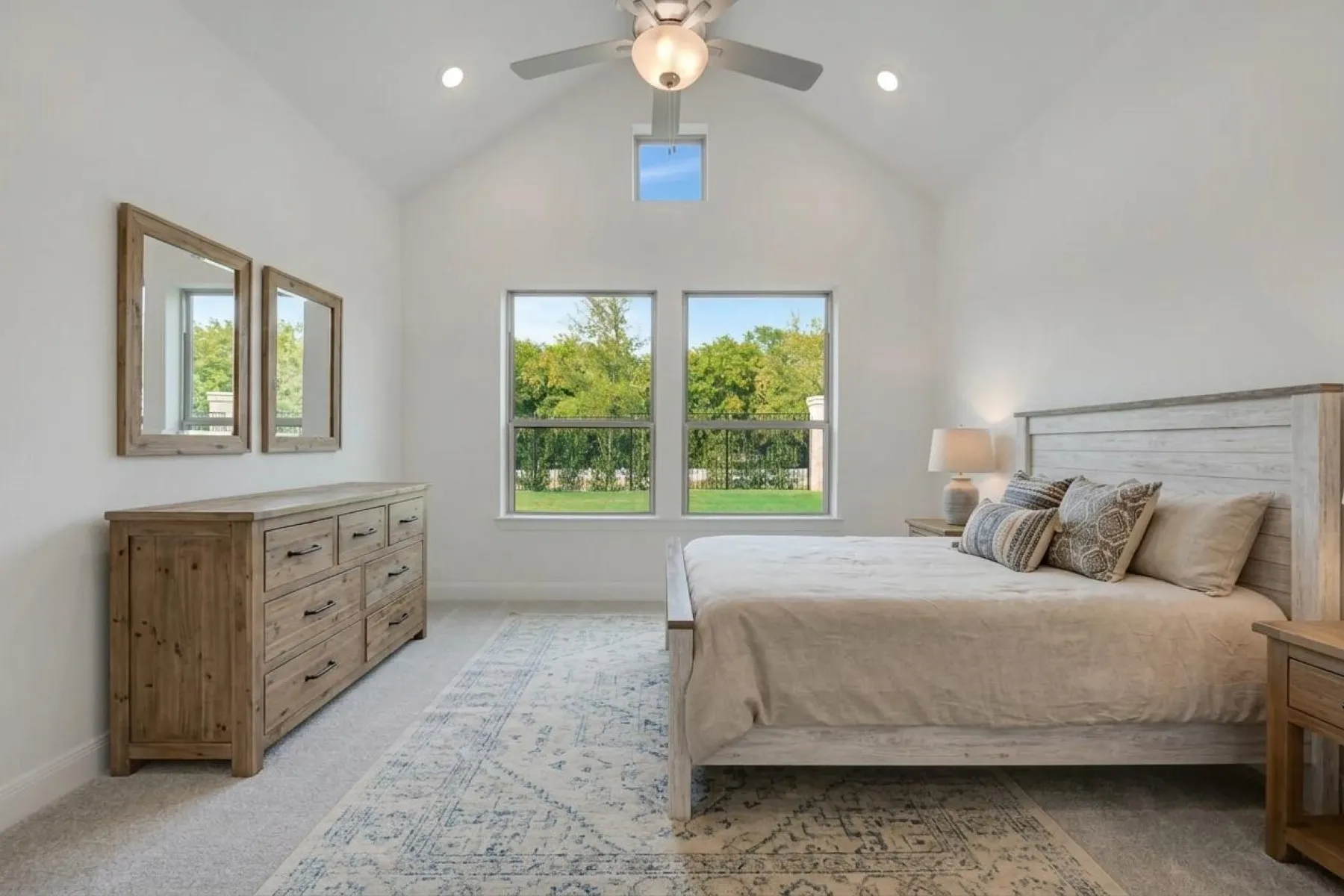 Vaulted ceiling with an integrated ceiling fan and recessed lighting, dual windows, and a skylight