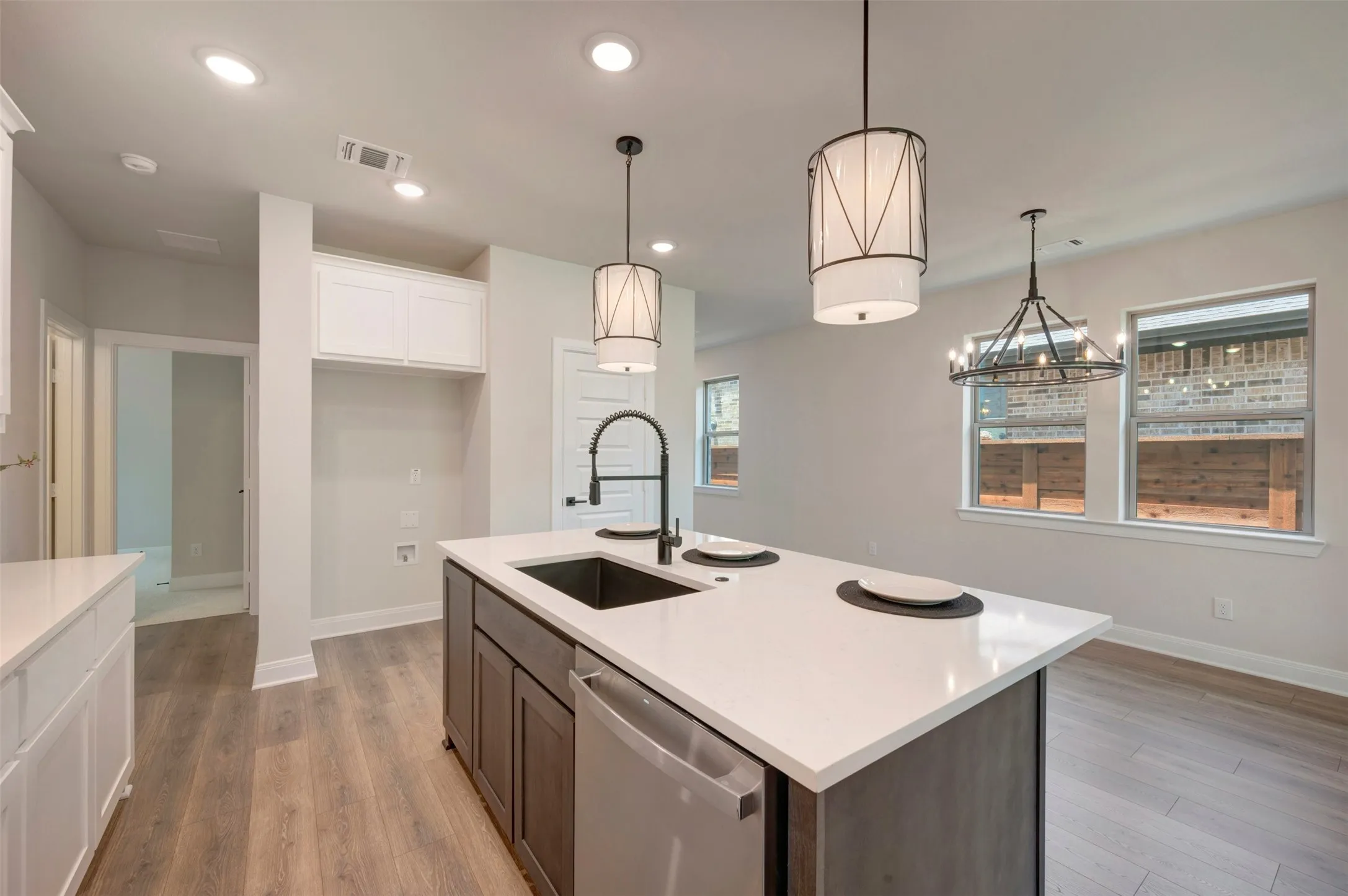 Modern kitchen island featuring a deep single-basin sink, gooseneck faucet, and quartz countertop