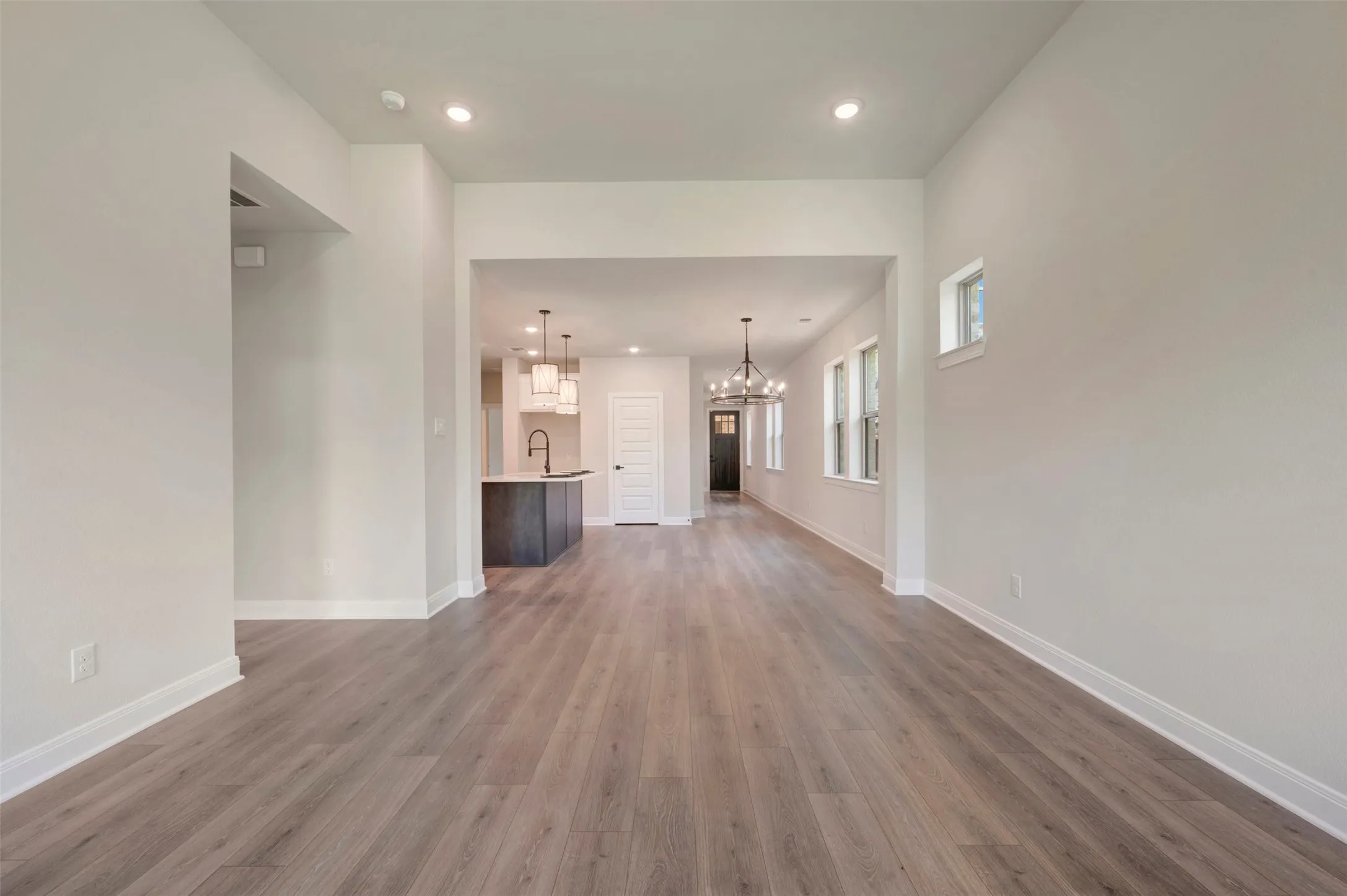 Open-concept living space with wood-finish flooring, white baseboards, and neutral wall tones