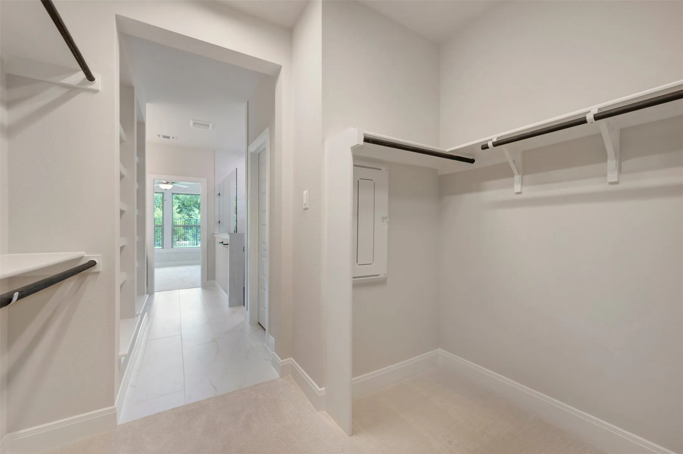 Walk-in closet featuring carpet flooring, built-in shelving, and hanging rods