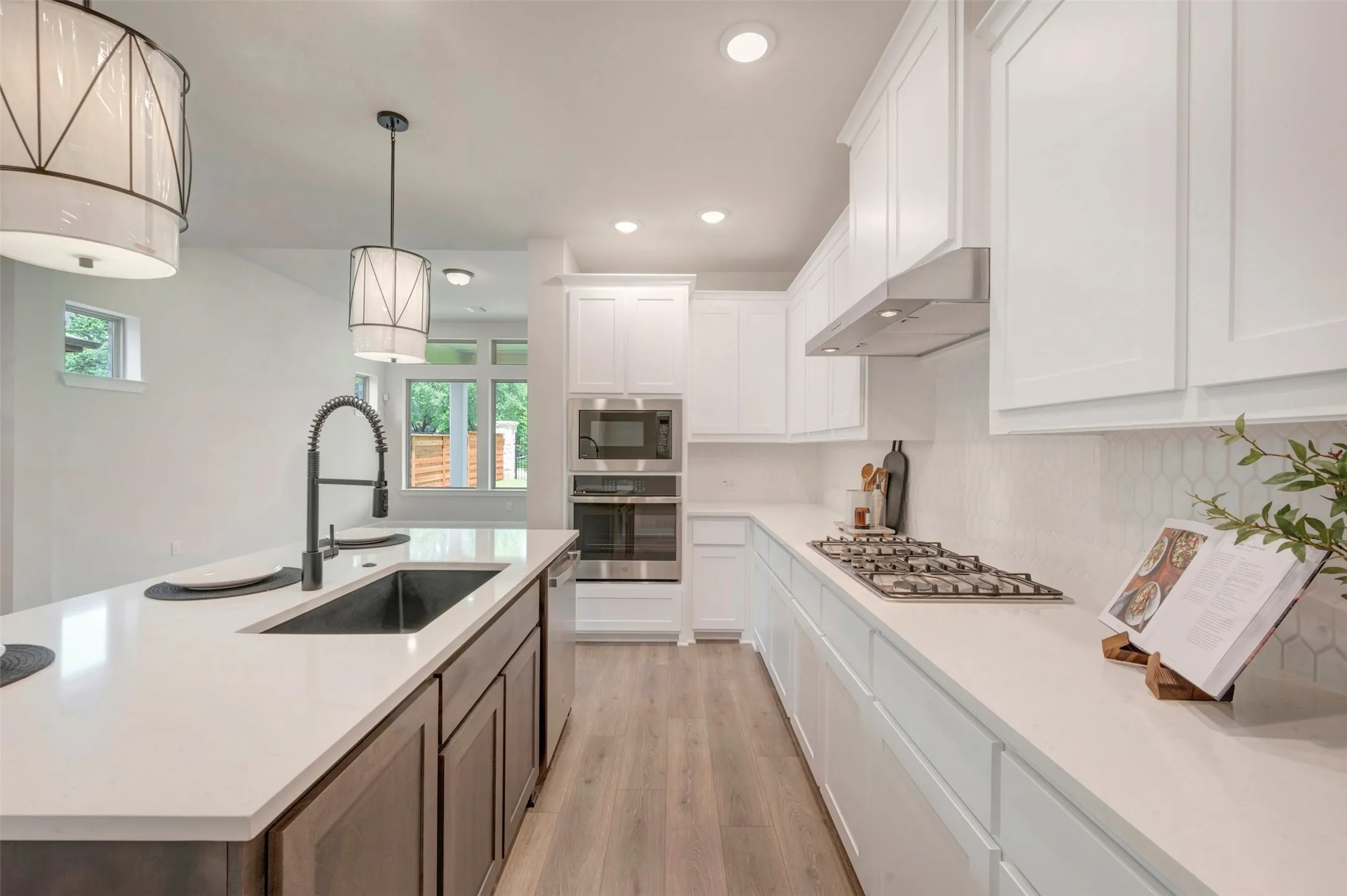 Bright kitchen featuring a central island with an undermount sink and gooseneck faucet