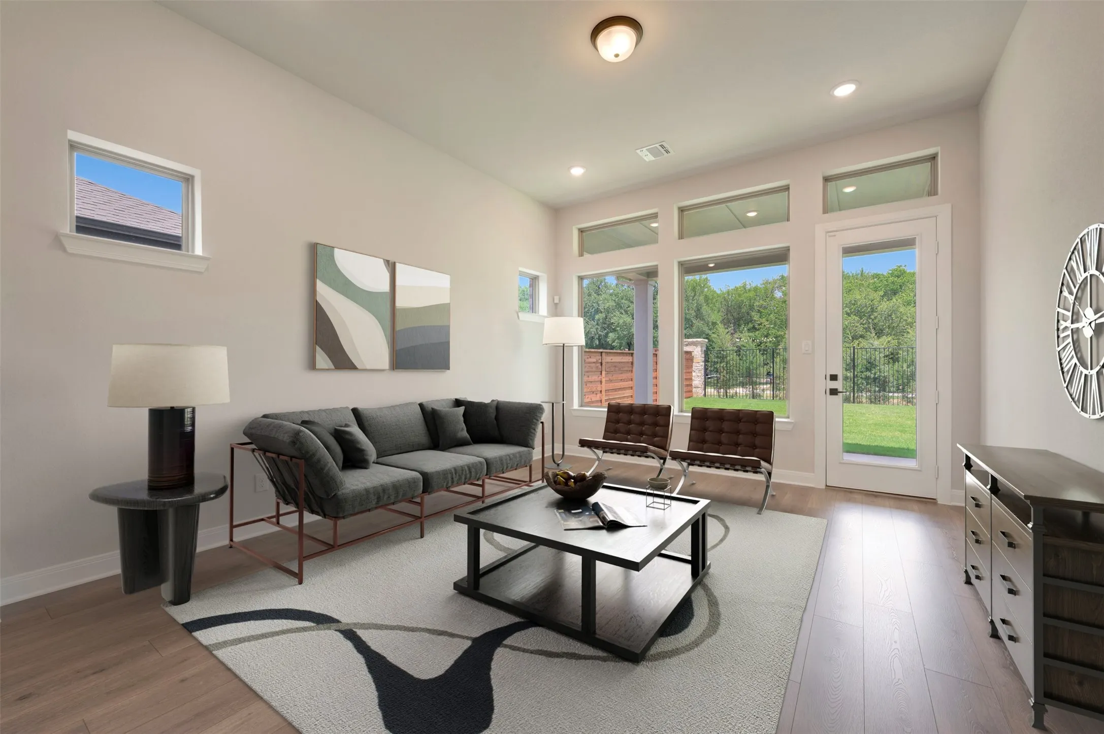 Bright living area featuring wood-finish flooring, a wall of full-height windows, a glass-paned exterior door, and recessed lighting