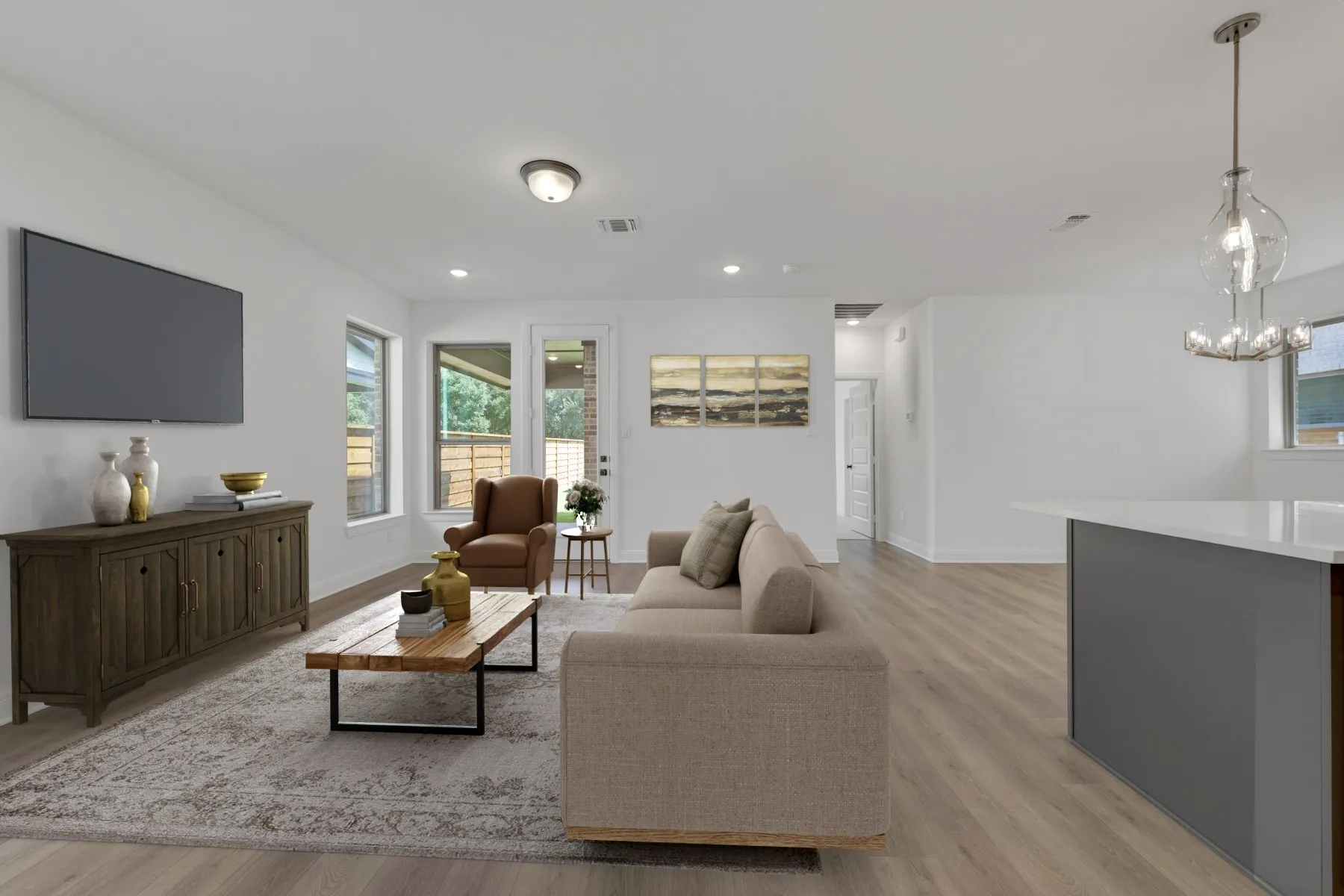 Open-concept living space featuring wood-finish flooring, recessed lighting, and a modern chandelier