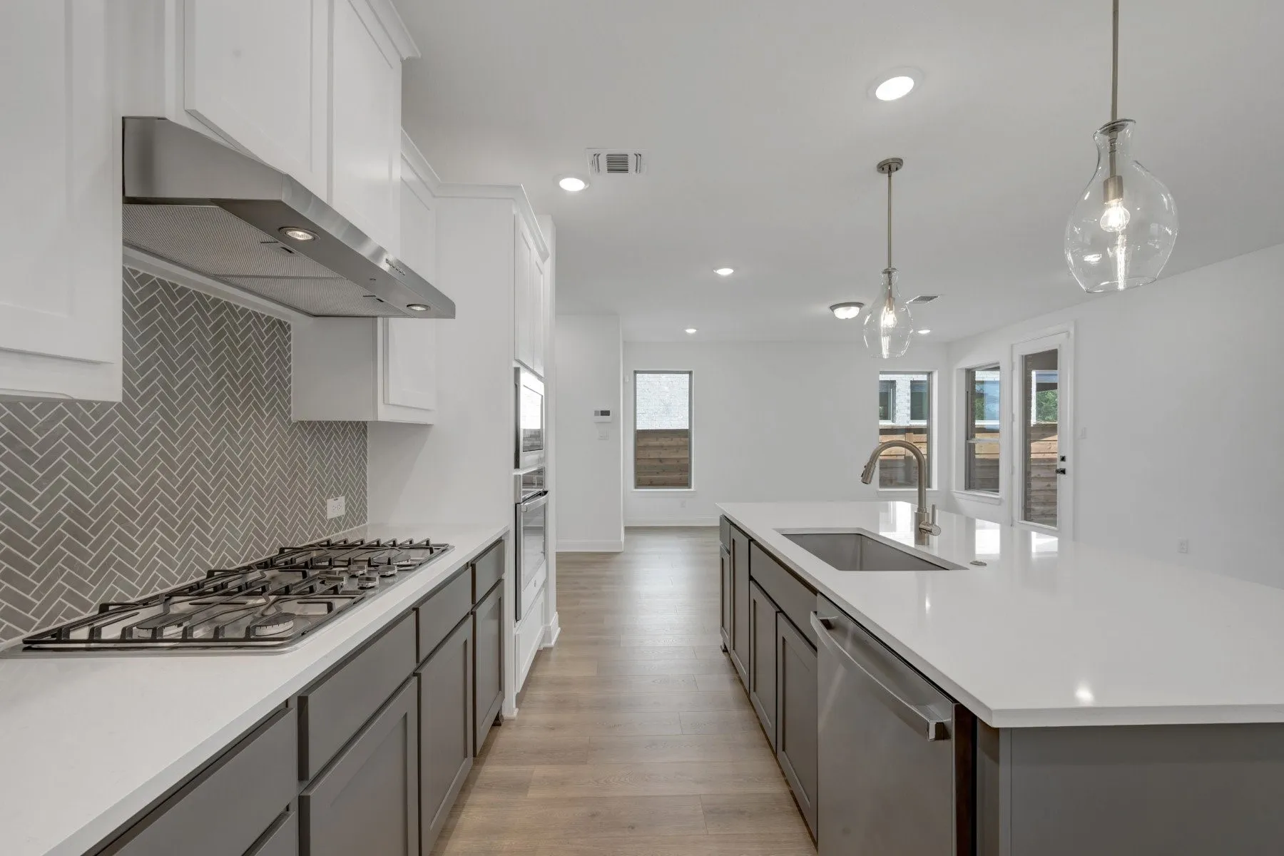 Modern kitchen featuring a gas range, stainless steel appliances, and a herringbone tile backsplash