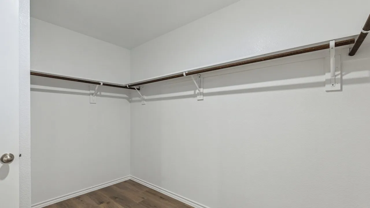 Walk in closet featuring dark wood finished floors
