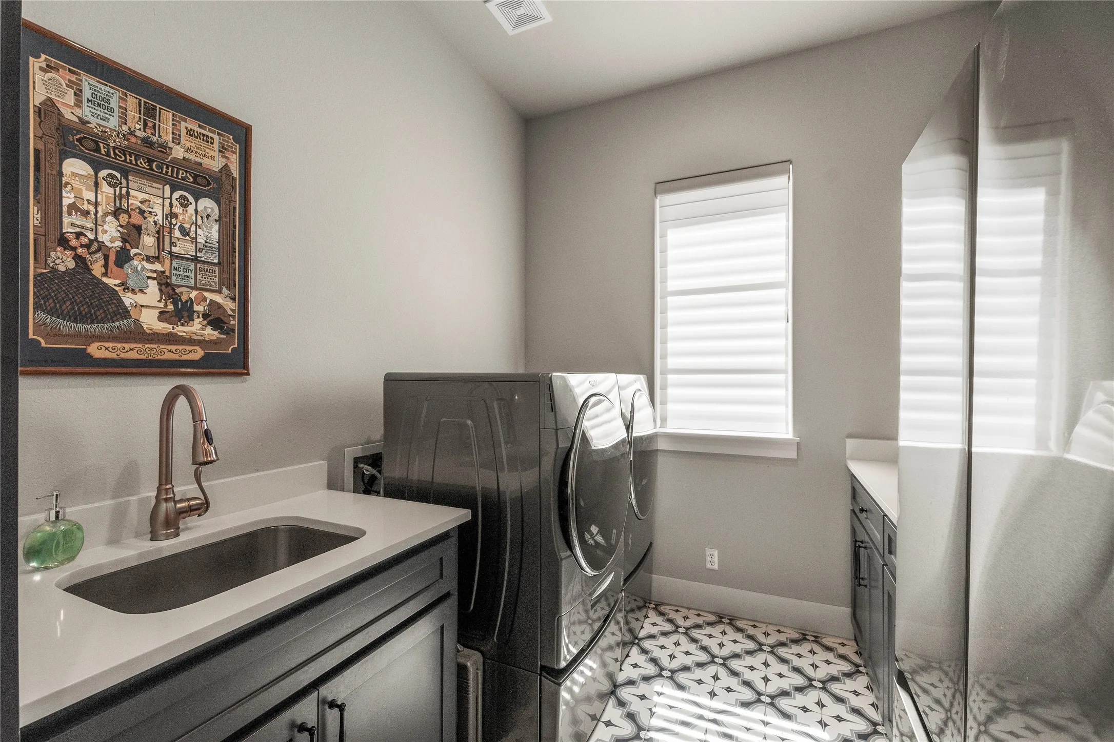 Utility room with sink, folding counter and room second refrigerator.