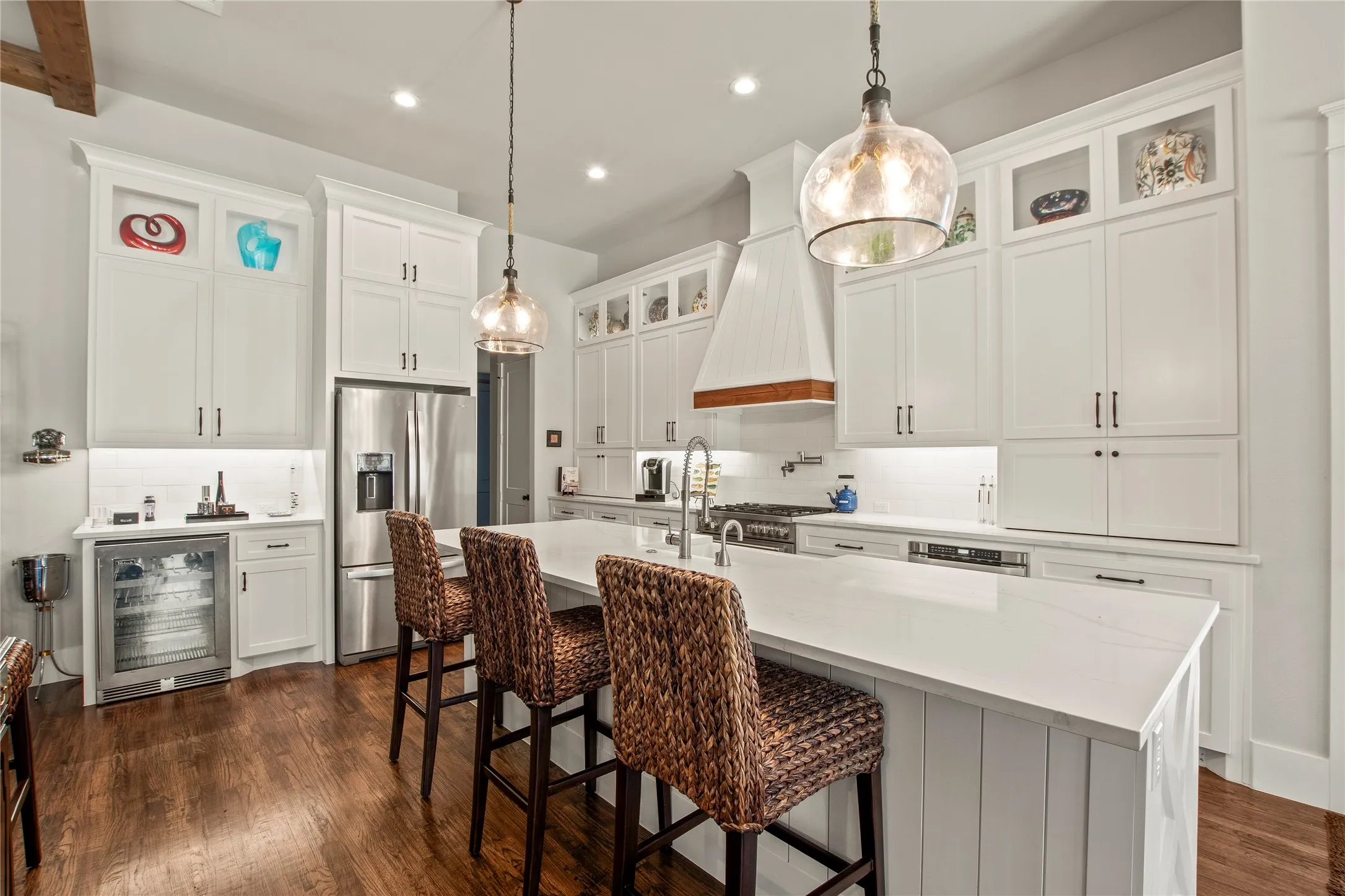 Kitchen features wine refrigerator, Bertazzoni 5 burner gas range, hot water pot filler over range, KitchenAid ice maker, quartz counter tops, custom cabinets, farm house sink.