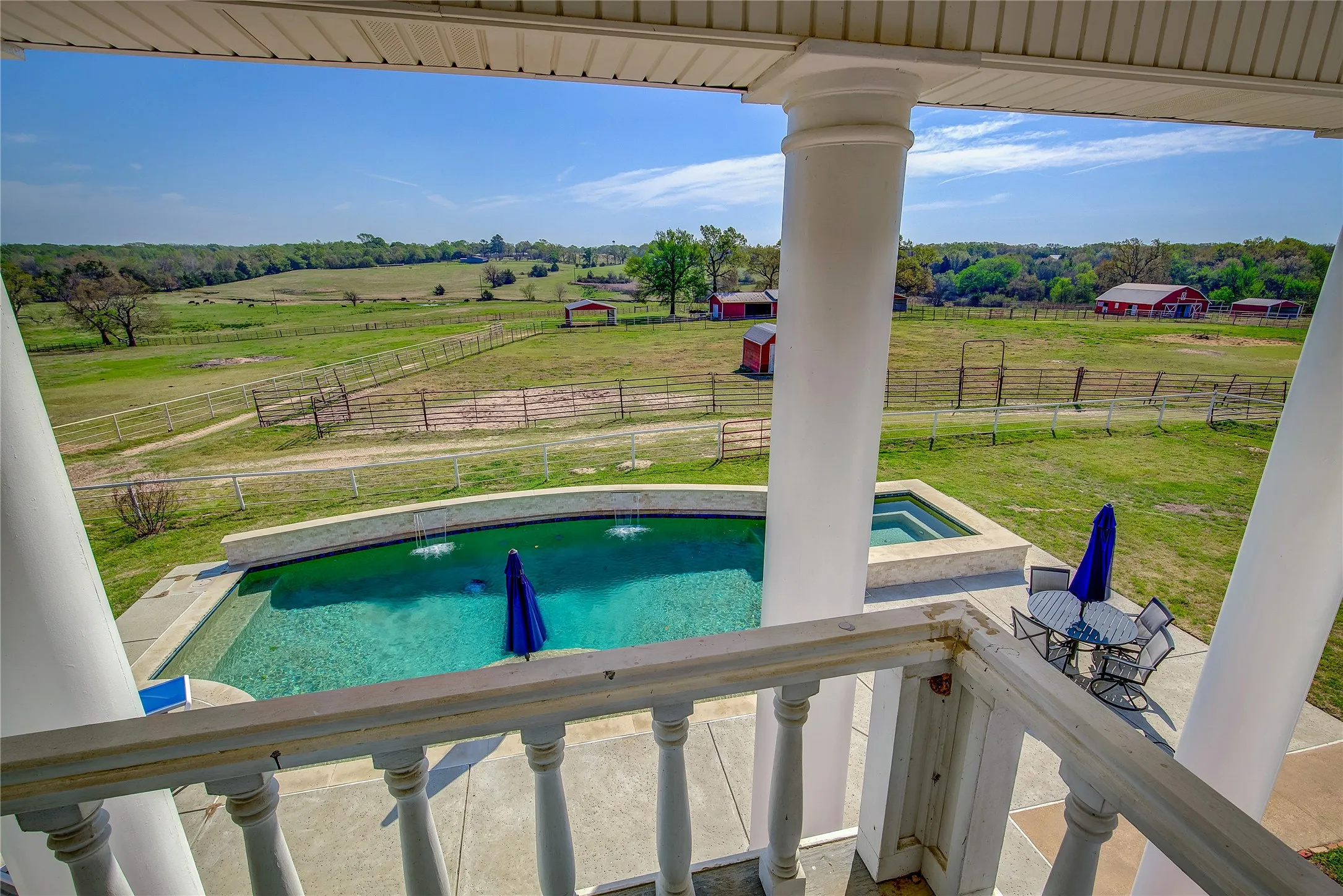 view of pool and property from upstairs primary balcony