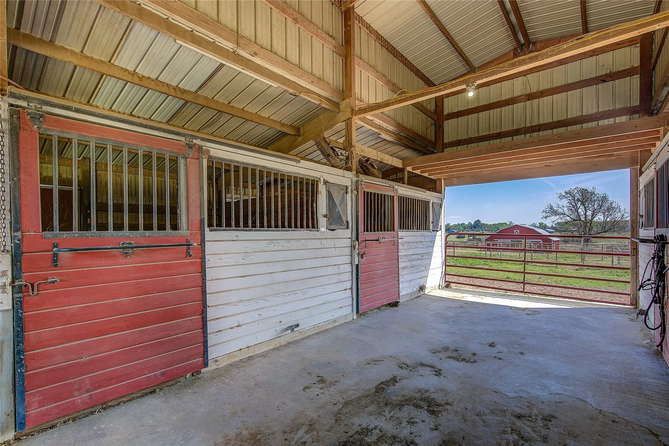 This stable has four stalls with bars, hay storage area, tack room, wash bay