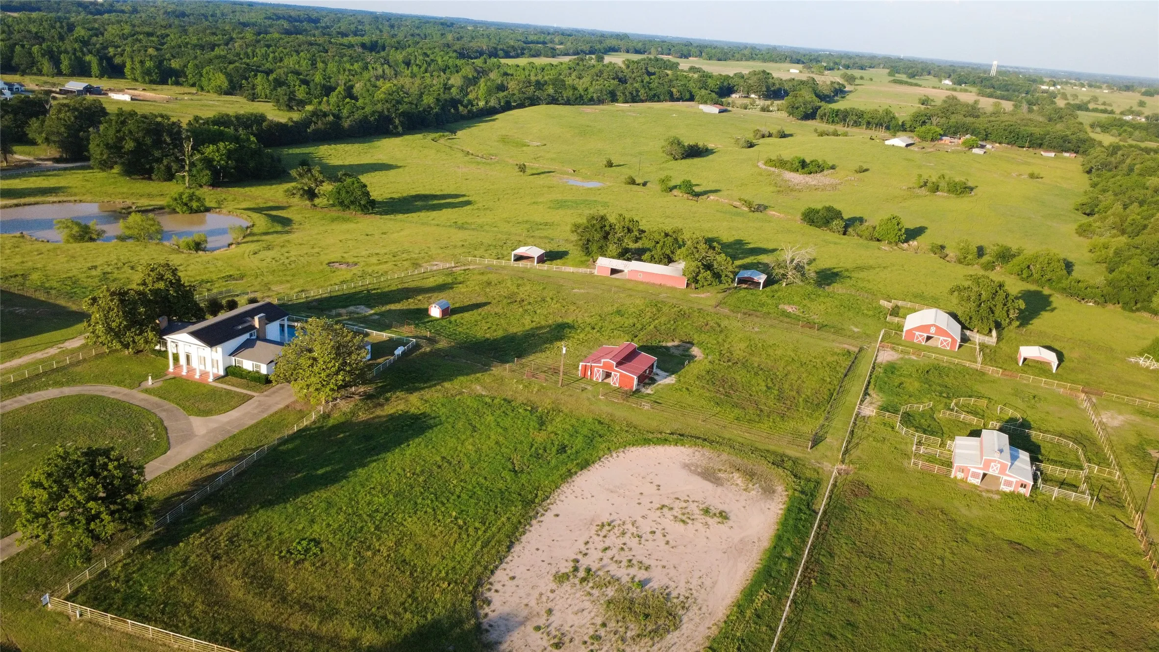 View of pond, house and outbuildings