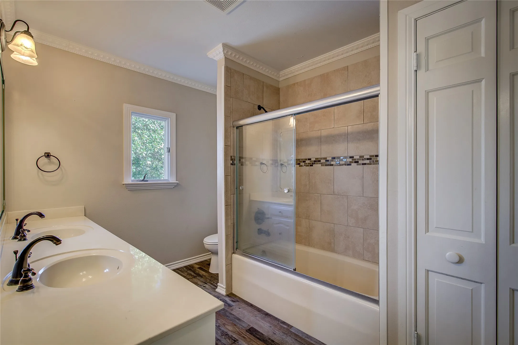 upstairs- hall bathroom (bath 3), double vanity, tub/shower combo with glass door, linen closet