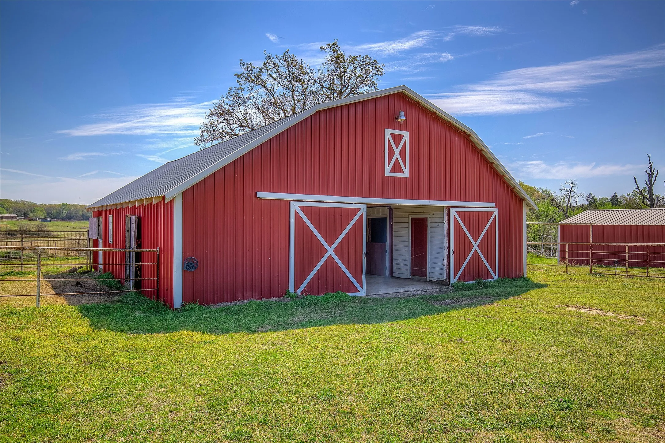 1 of THREE horse barns on the property; 14 stalls total, plus tack rooms, stud pen, wash bay, hay storage and stocks