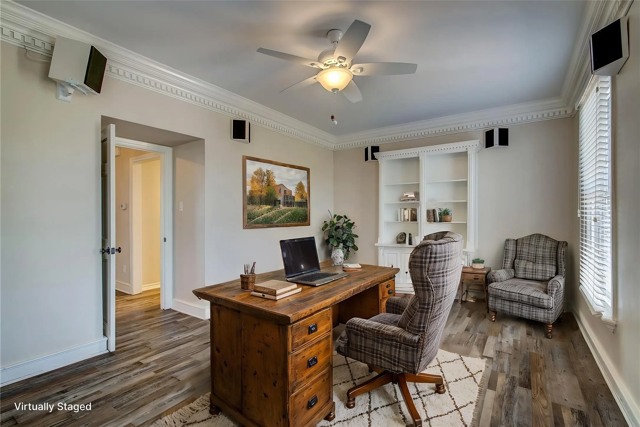 Home office is off of entry foyer, with installed speakers, dentil and crown molding, 6-inch baseboards