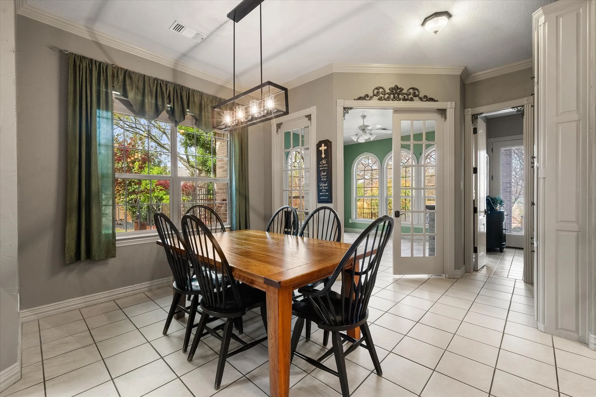Breakfast area with ornamental molding, healthy amount of natural light, suspended lighting, and light tile patterned floors