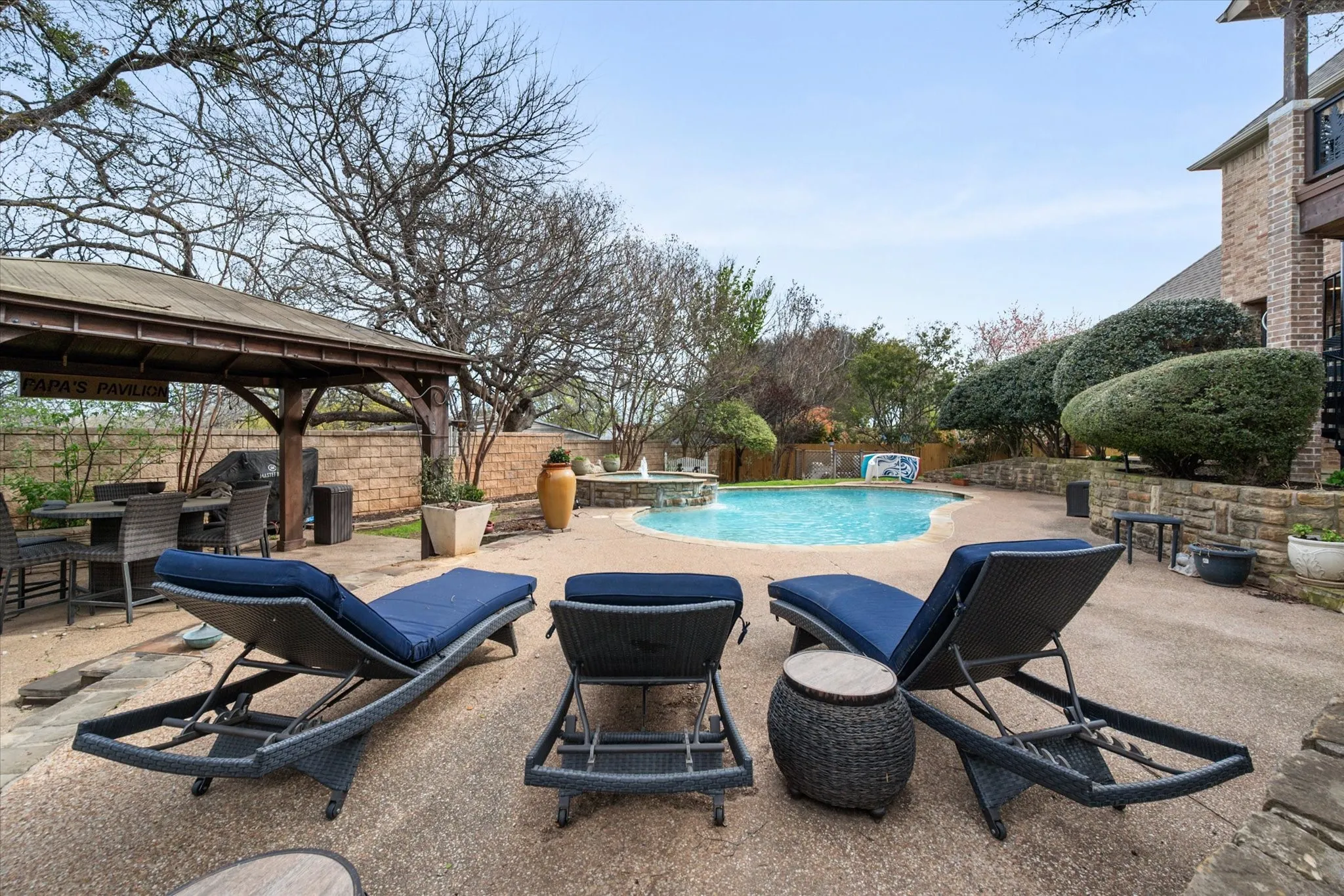 Combined pool / hot tub with a patio area, a fenced backyard, and a grill