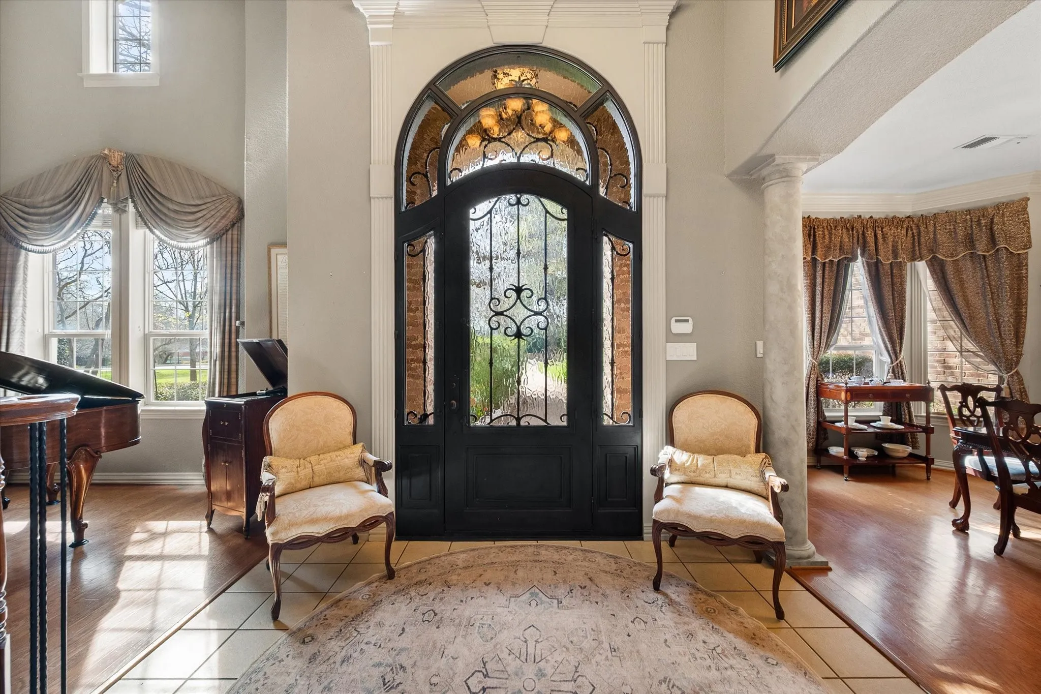 Foyer entrance with ornamental molding, tile patterned flooring, and a high ceiling!