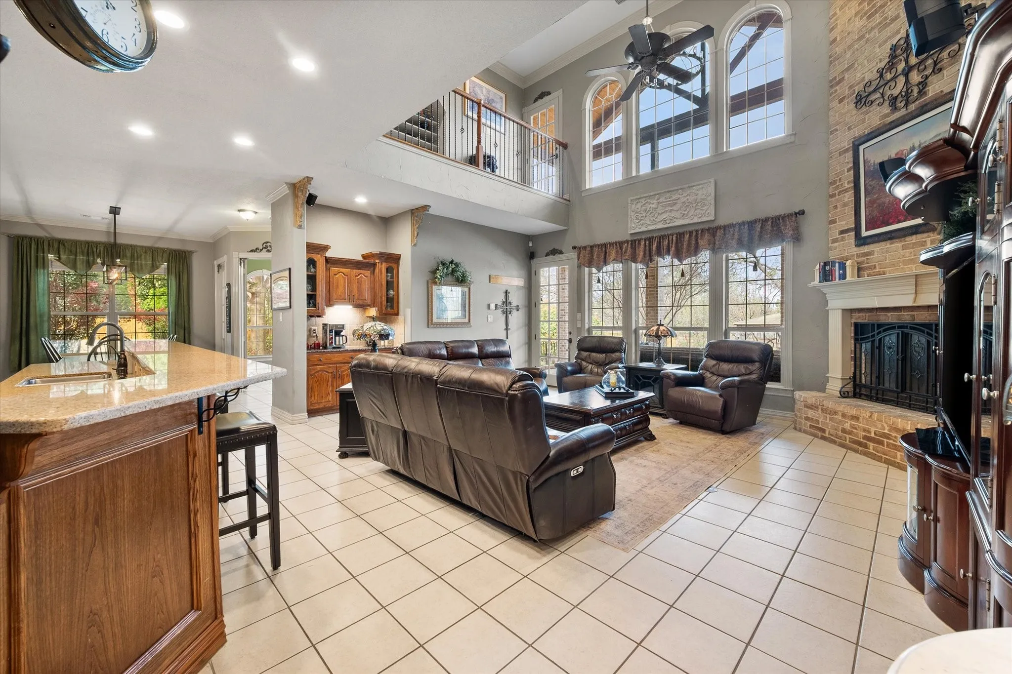 Living area featuring  a fireplace, a ceiling fan, crown molding, and recessed lighting!