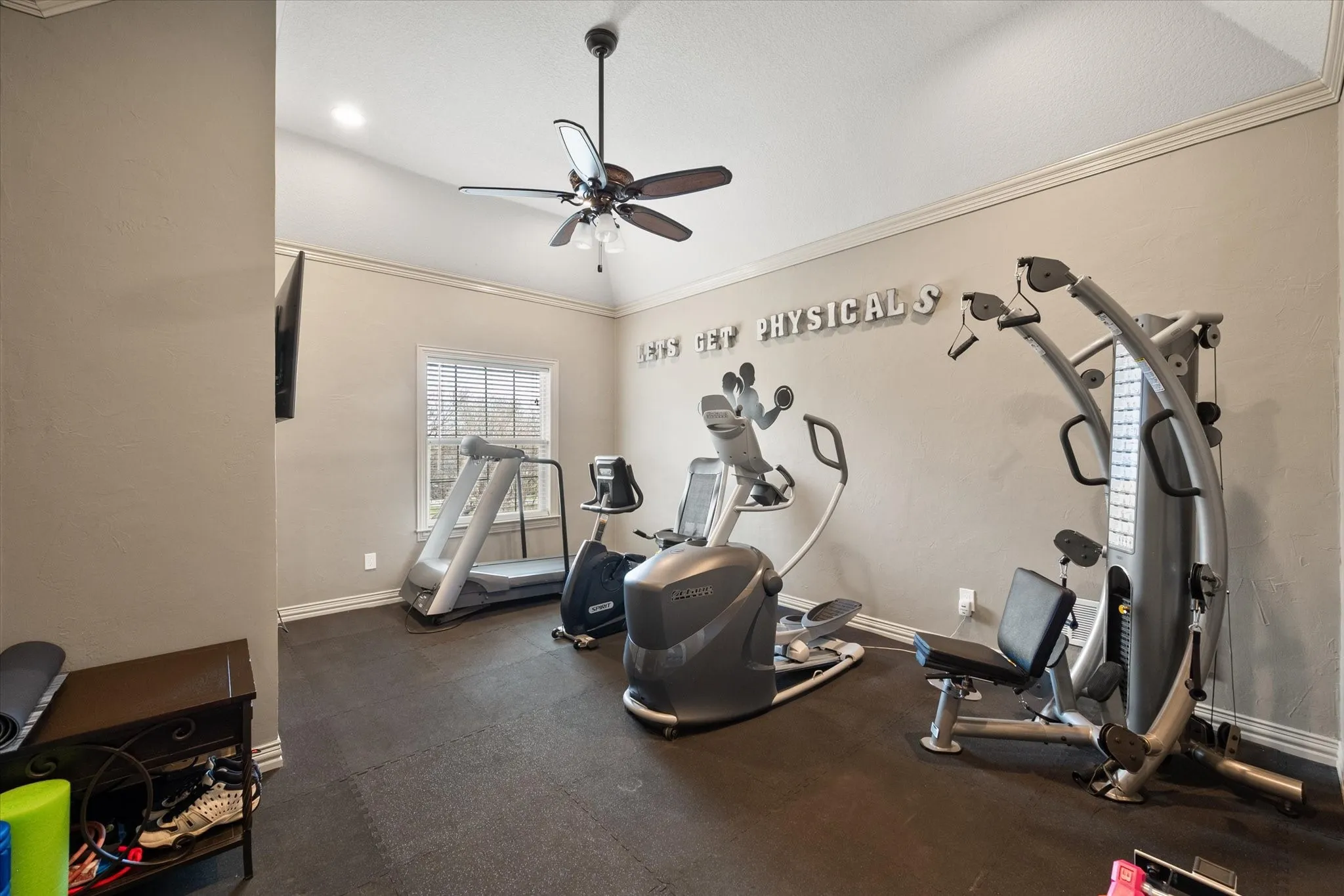 Bedroom currently used as exercise room featuring a ceiling fan and ornamental molding