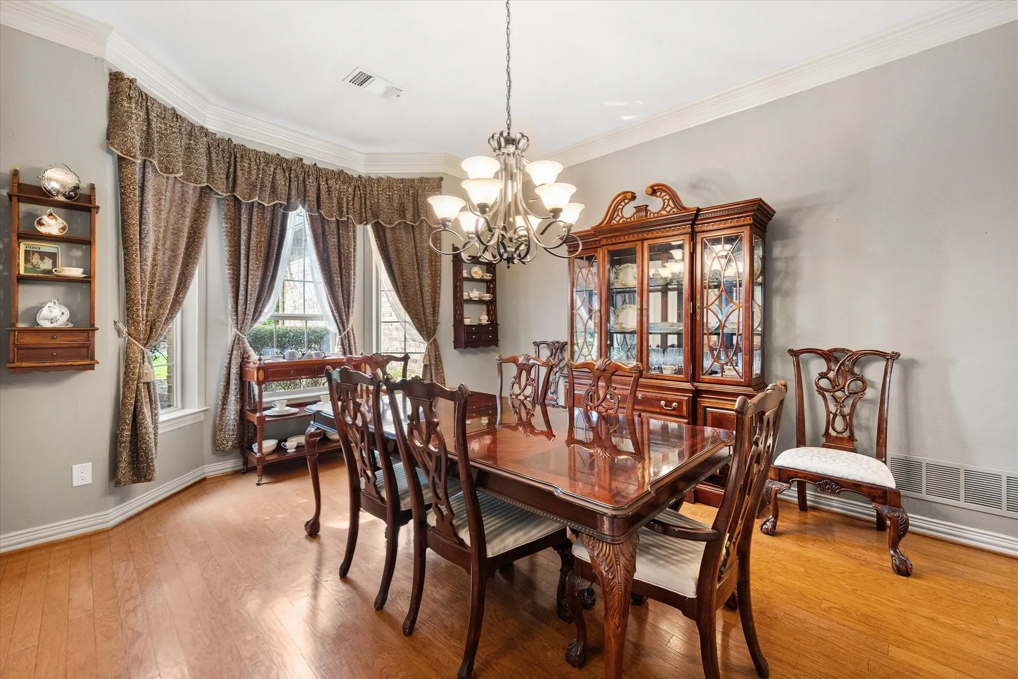Dining area with a chandelier, light wood-style flooring, and crown molding