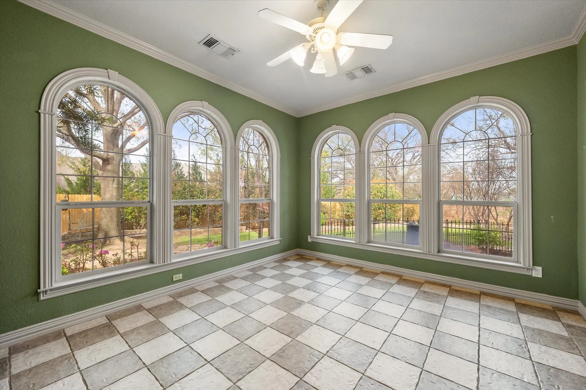 Sunroom featuring a ceiling fan, crown molding, and healthy amount of natural light