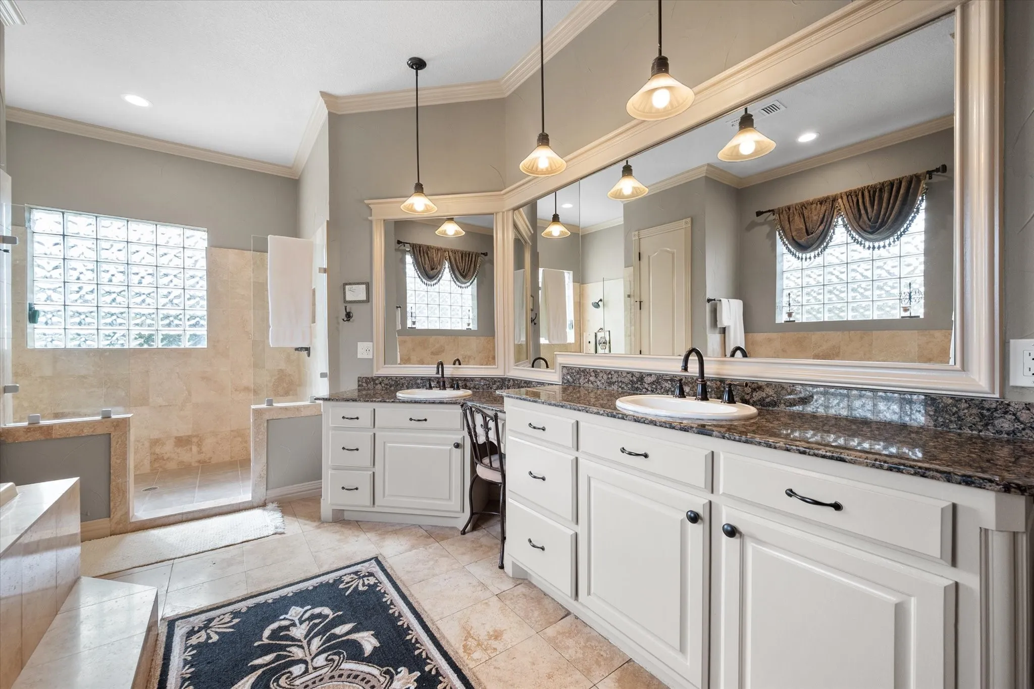 Full bathroom featuring two vanities, plenty of natural light, walk in shower, ornamental molding, and recessed lighting