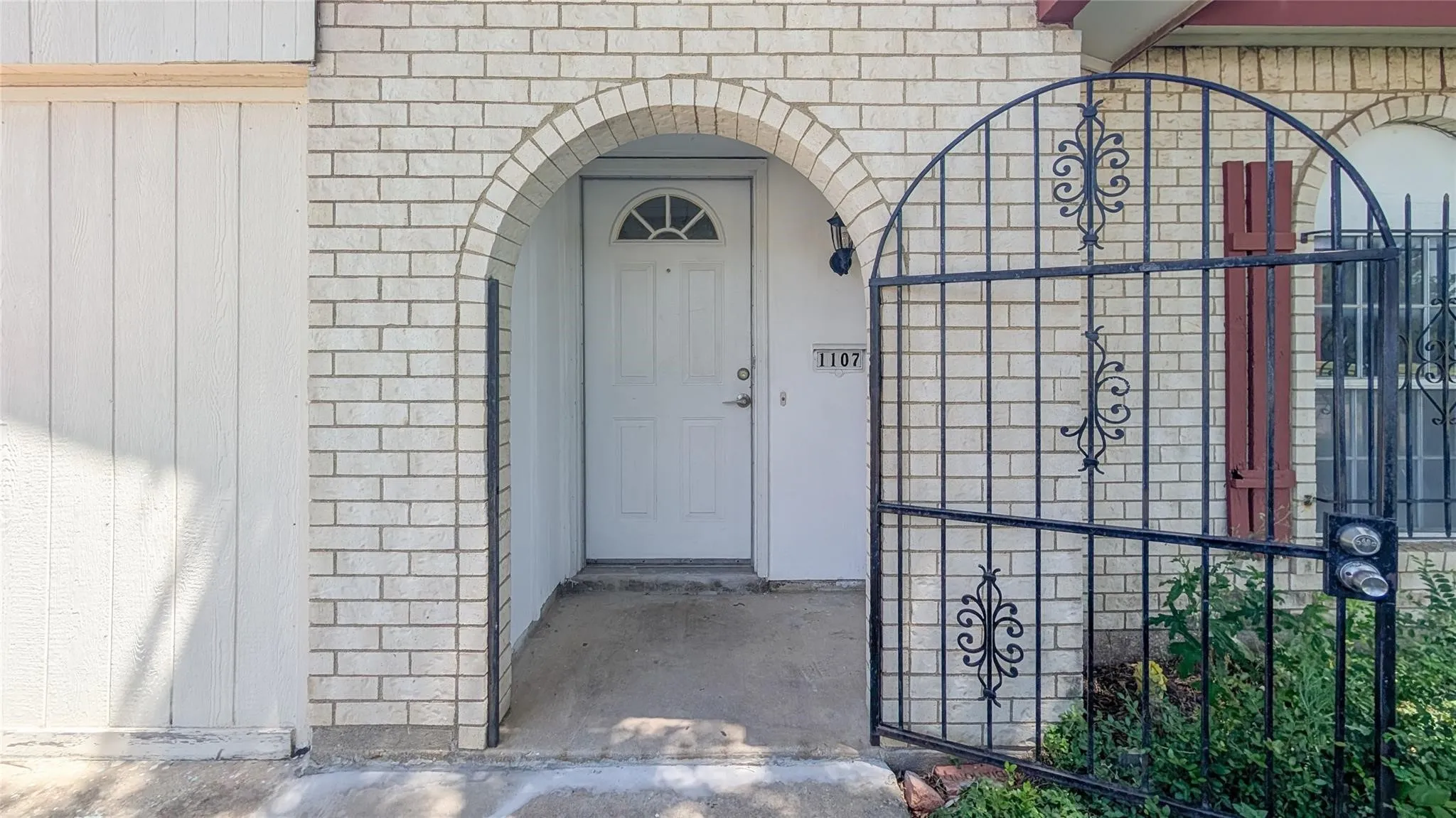 Doorway to property with brick siding and a gate