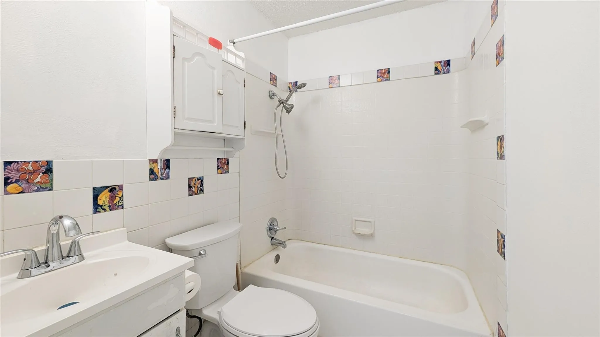 Bathroom with vanity, tile walls, and bathtub / shower combination