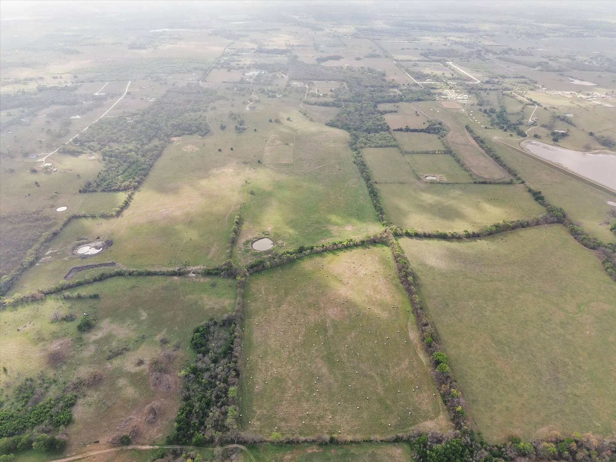 Aerial view of property and surrounding area featuring rural landscape and farmland