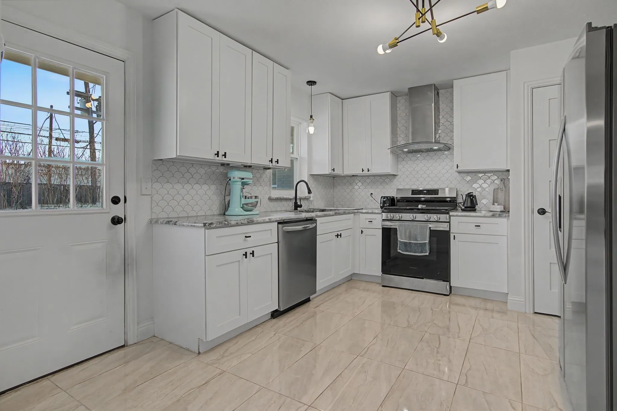 Updated Kitchen featuring Stainless Steel appliances, granite counters and scalloped backsplash