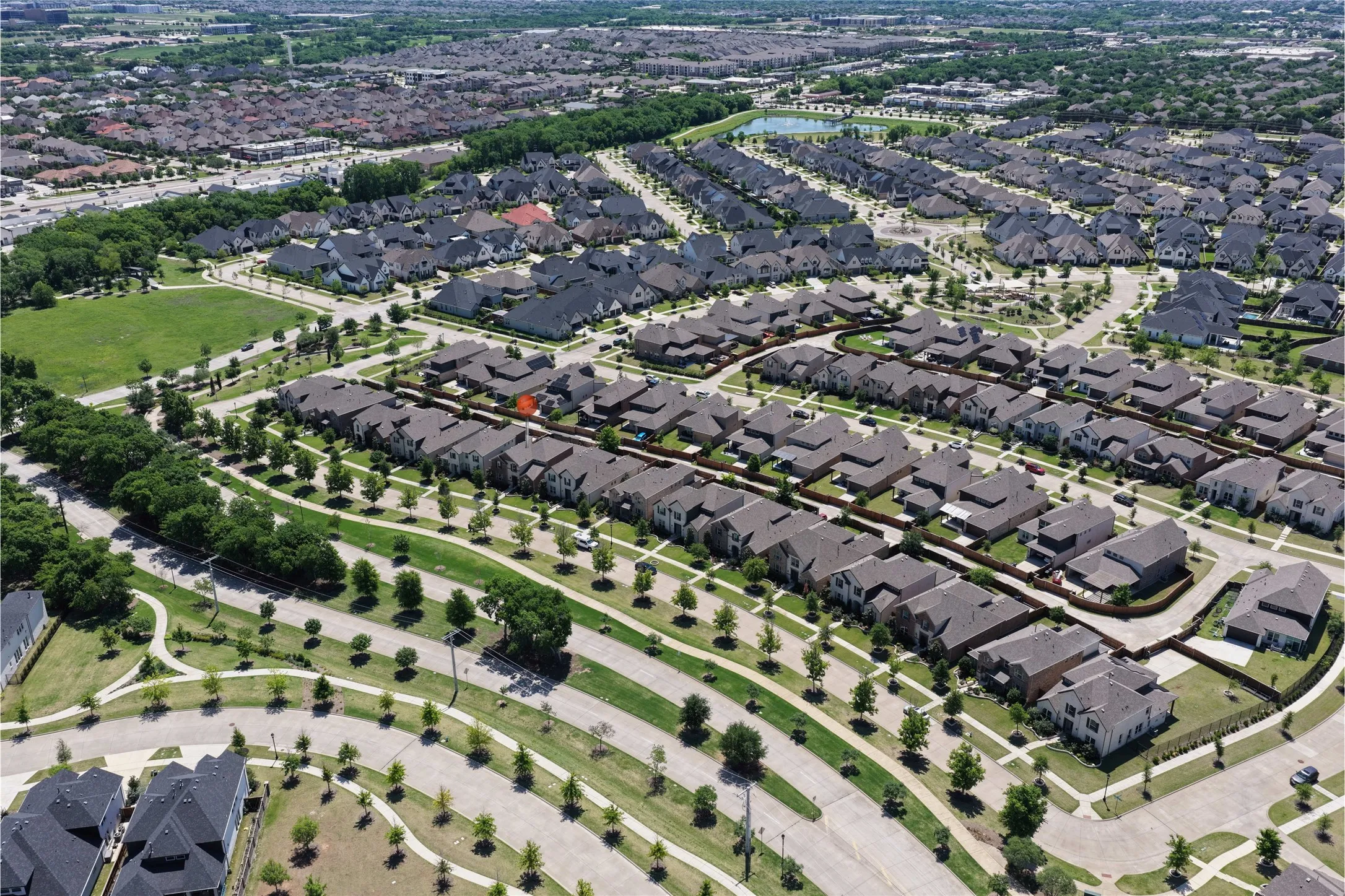Expansive residential development featuring numerous single-family homes with uniform rooflines