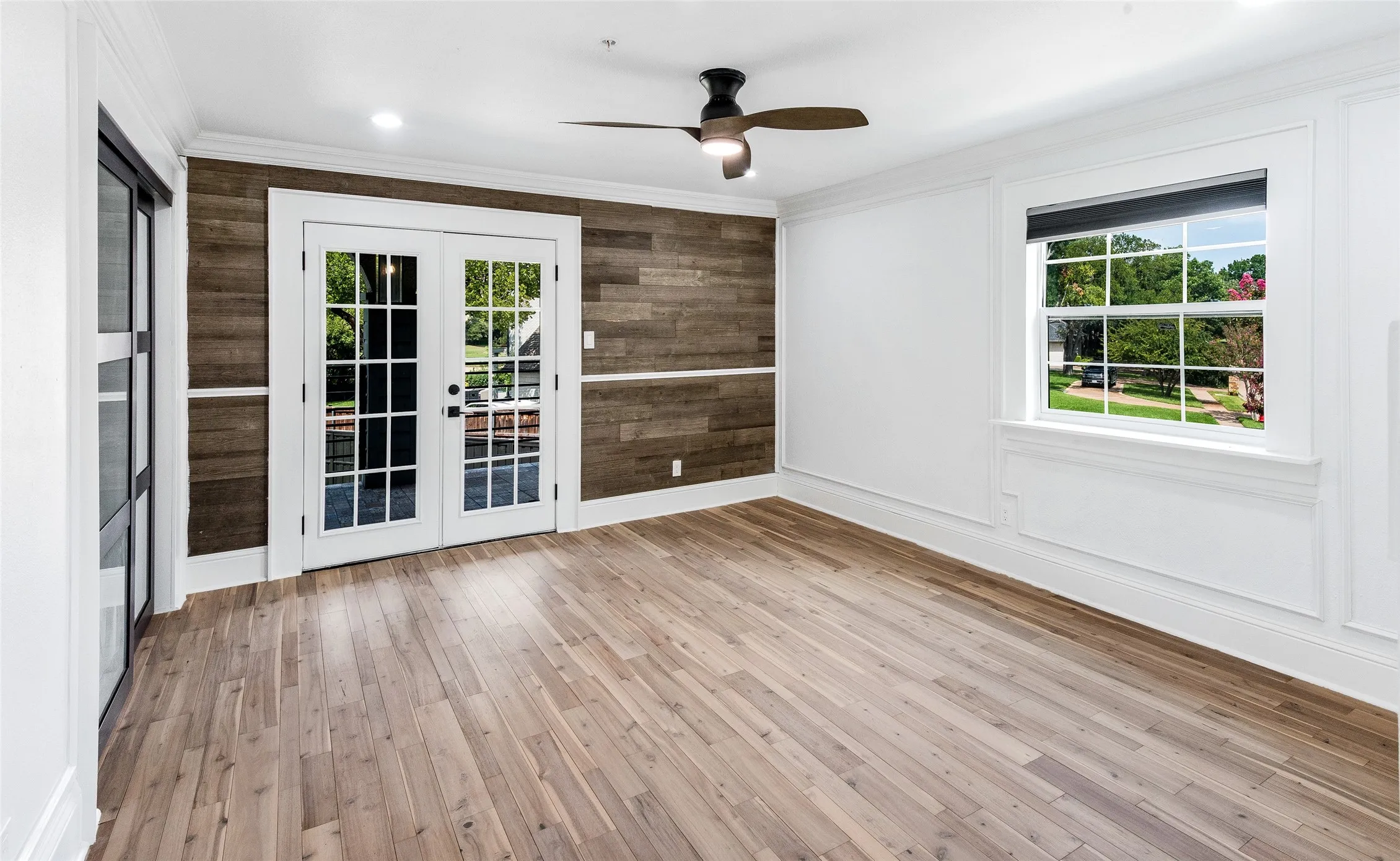 Empty room with french doors, light wood-type flooring, ceiling fan, ornamental molding, and recessed lighting