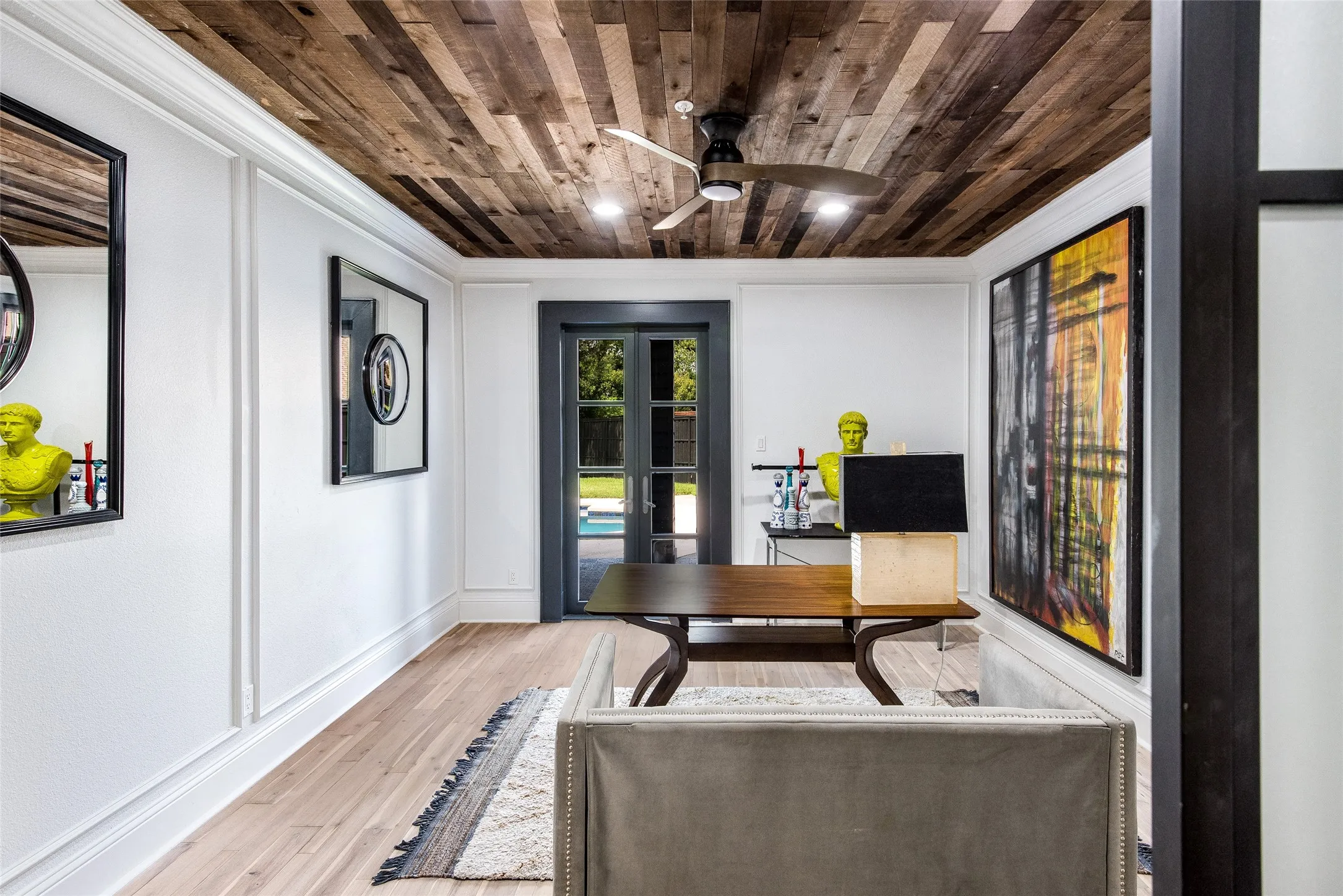 Office space with wood finished floors, a ceiling fan, wooden ceiling, and crown molding