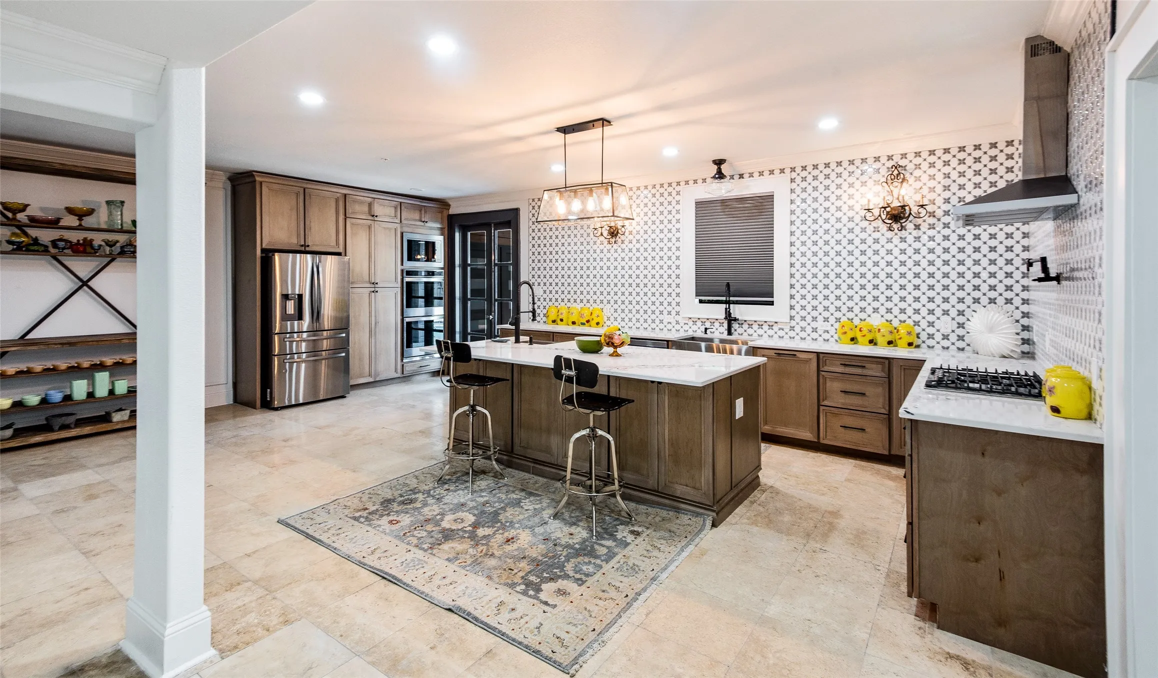 Kitchen with a kitchen island with sink, stainless steel appliances, a kitchen bar, decorative light fixtures, and decorative backsplash