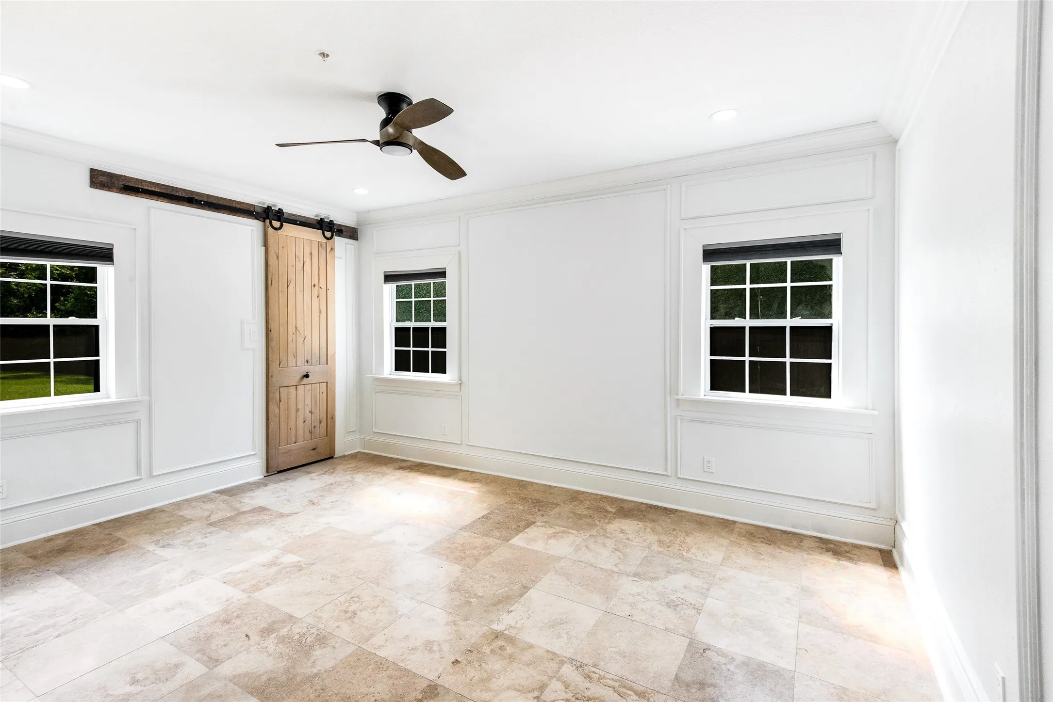 Unfurnished room featuring ornamental molding, ceiling fan, a barn door, and recessed lighting