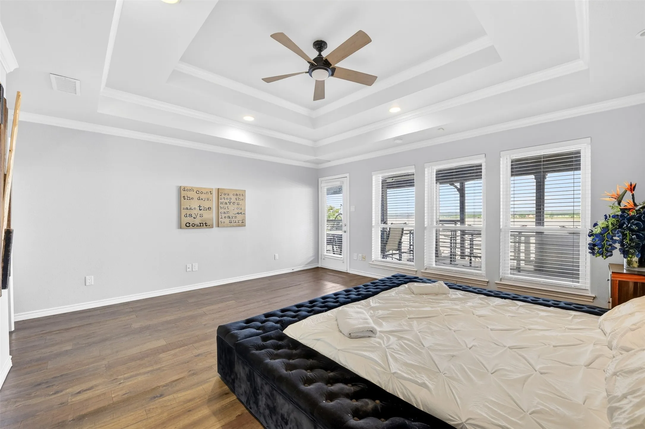 Large primary bedroom with large windows overlooking the lake