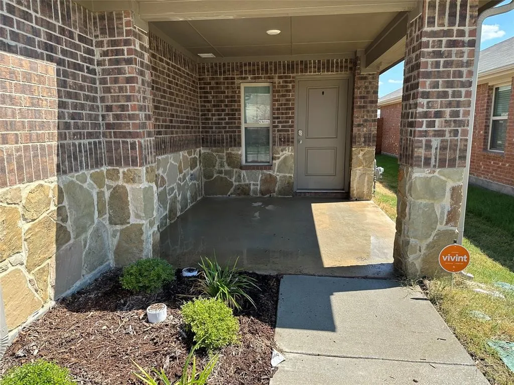 View of exterior entry featuring brick siding and stone siding