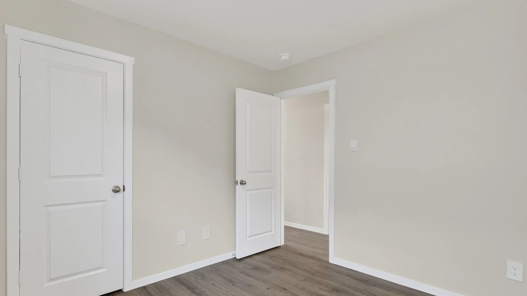 Recessed ceiling lighting, wood-finish flooring, white panel doors, and neutral wall paint