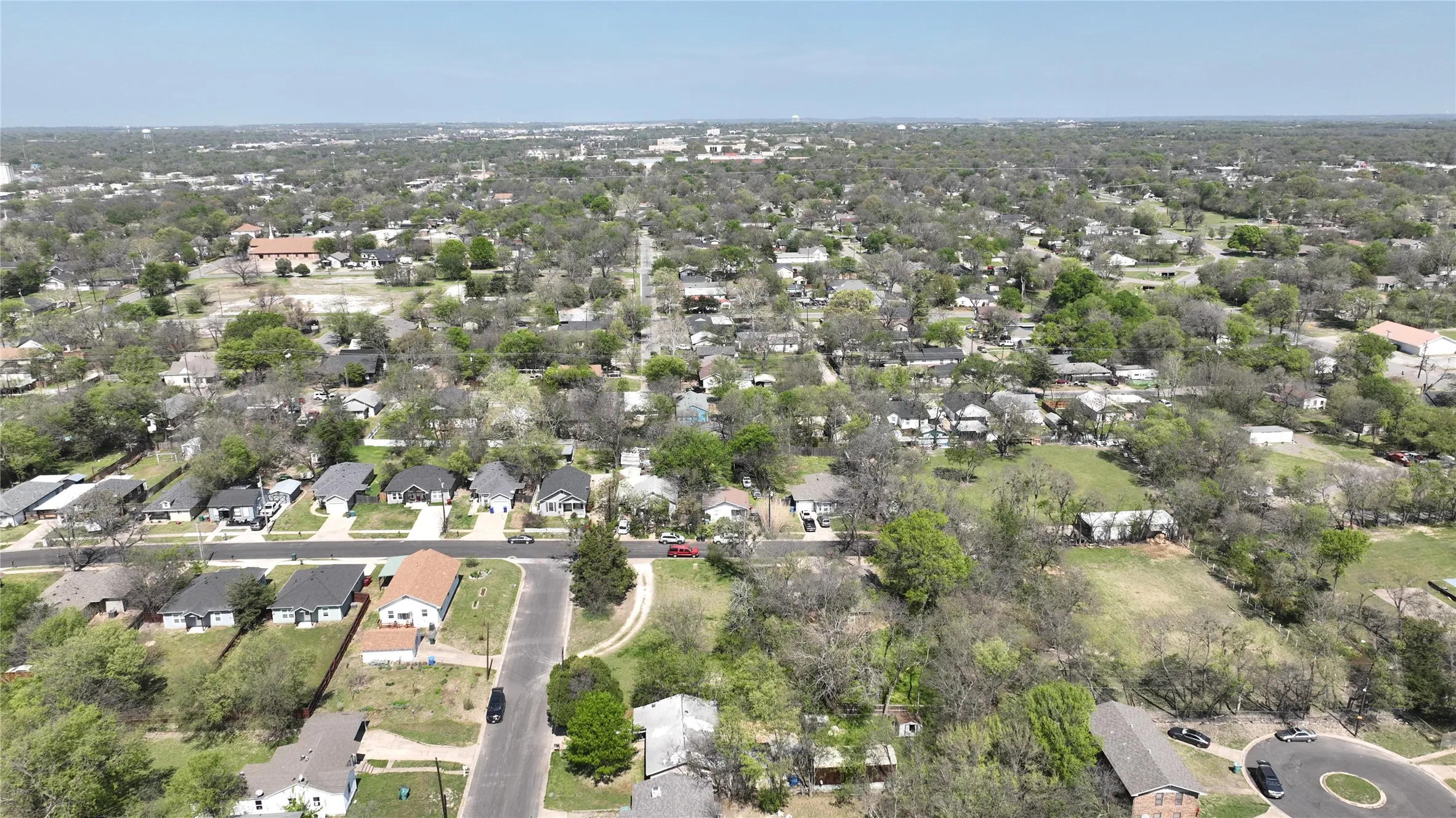 Aerial view of property and surrounding area featuring nearby suburban area
