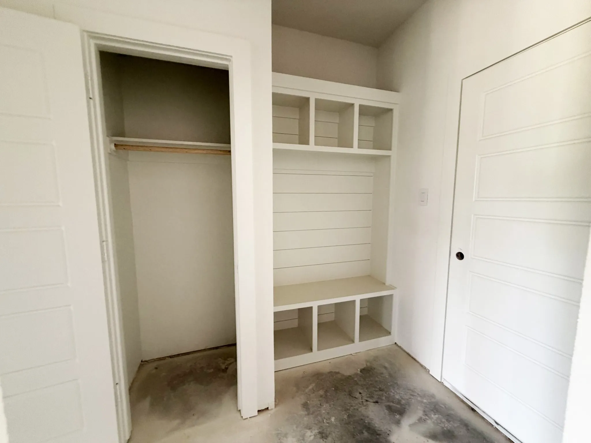 Built-in storage bench with cubbies, shiplap detailing, and upper cubby shelving